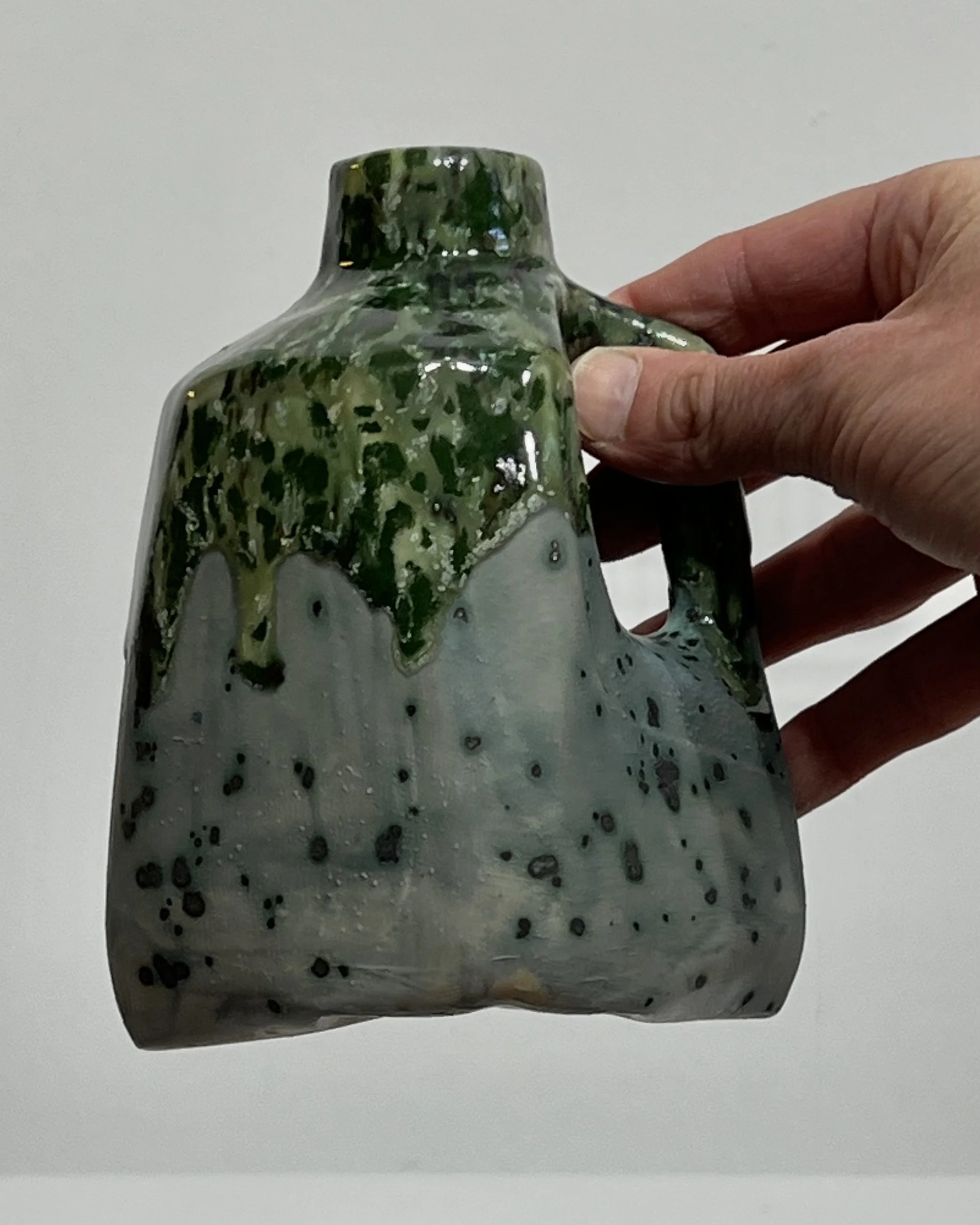 Small ceramic milk jug 26.122 held in hand to illustrate its approximate five-inch height