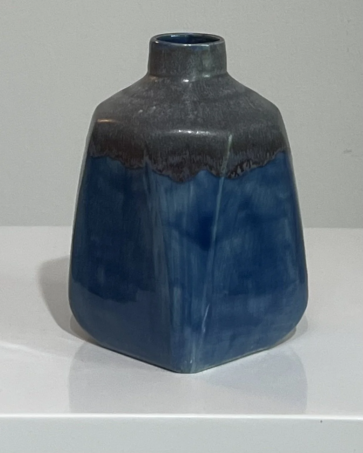 Back view of a handmade porcelain milk jug showing layered cobalt blue glaze with smoky gray shoulders.