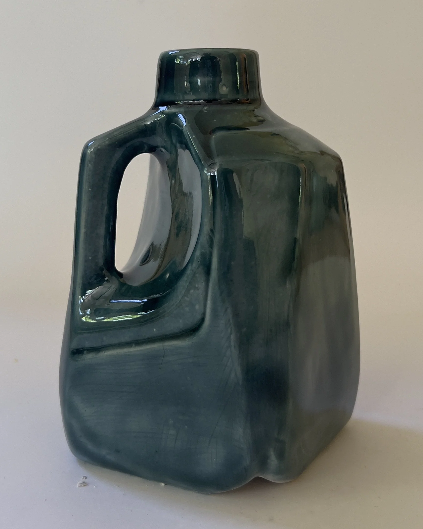 Side view of sculptural ceramic jug vase with dark teal rainforest glaze