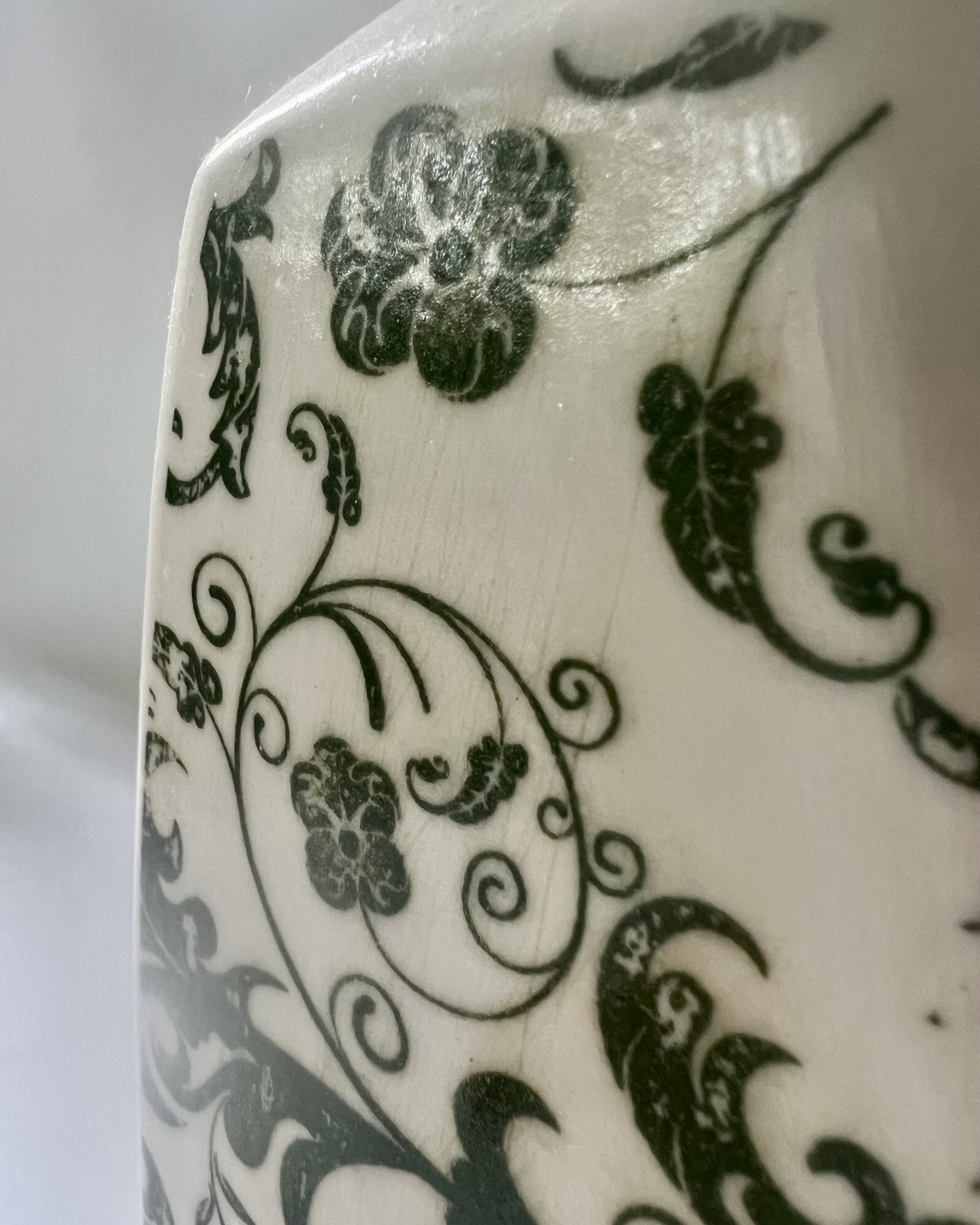 Close-up detail of the botanical transfer and glossy clear glaze on a handcrafted porcelain milk jug.