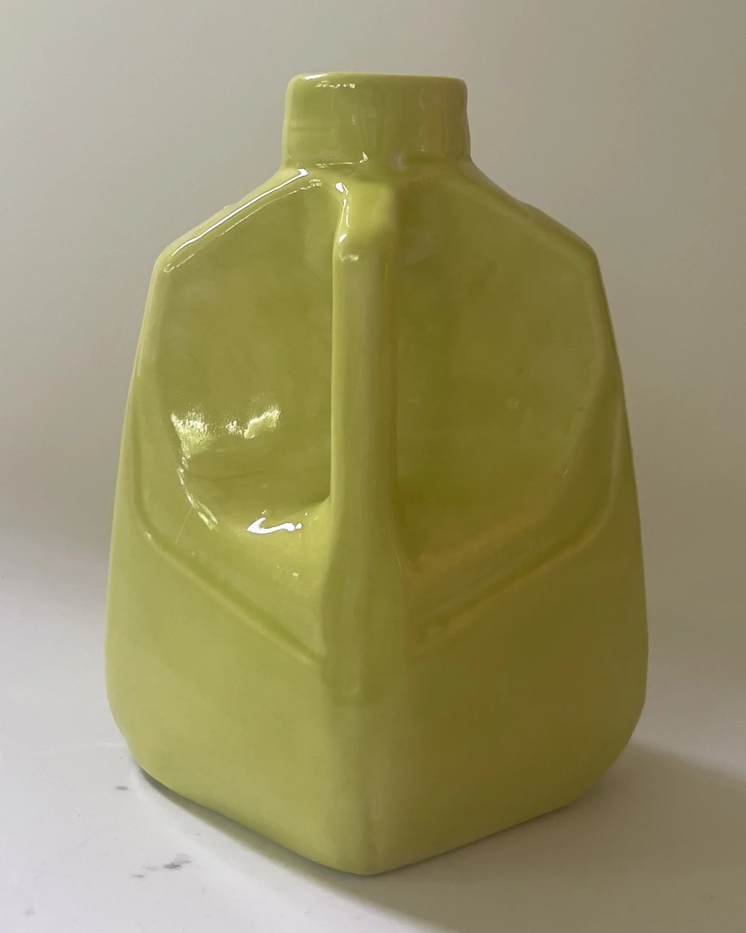 Back view of handmade ceramic vessel in neon yellow-green Pear glaze.