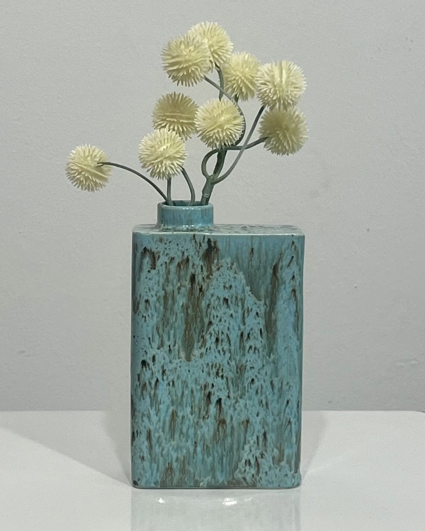 Handmade porcelain carton vase in Cenote glaze with flowing turquoise blue and earthy brown tones.