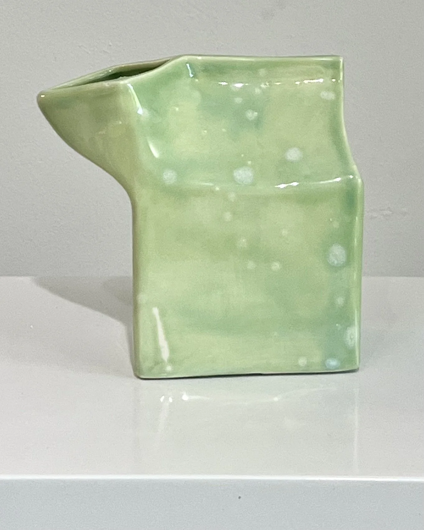 Front view of handmade porcelain milk carton finished in Celadon Bloom over Saguaro glaze.