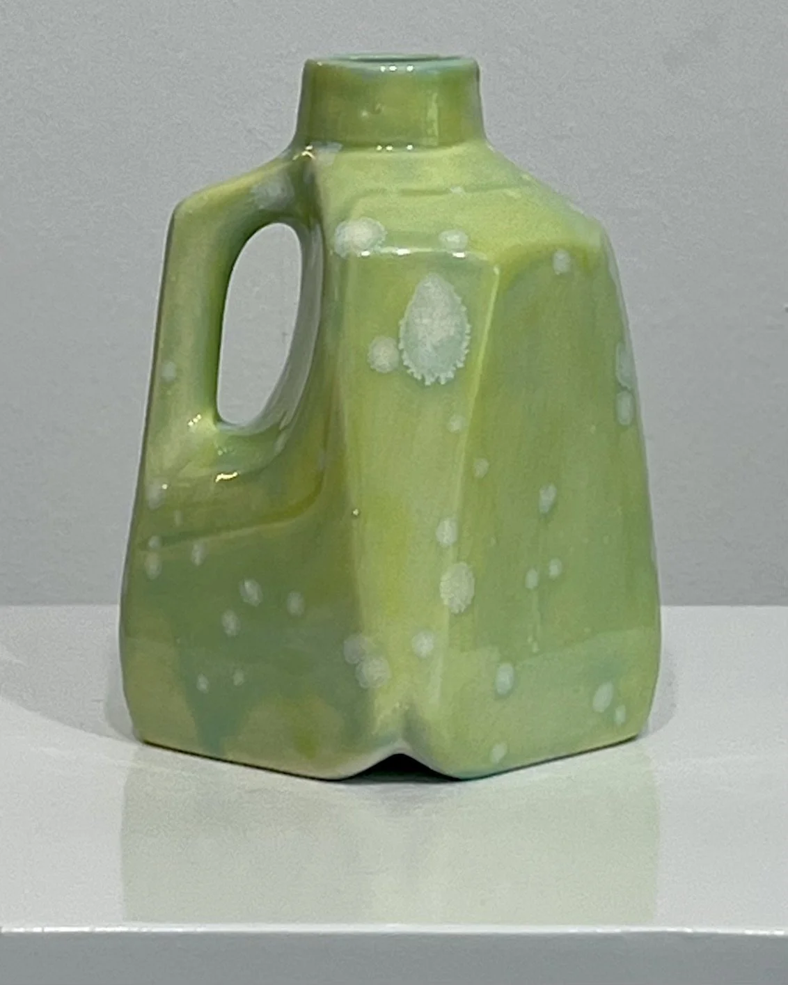 Side view of porcelain milk jug showing integrated handle and Celadon Bloom over Pear glaze combination.