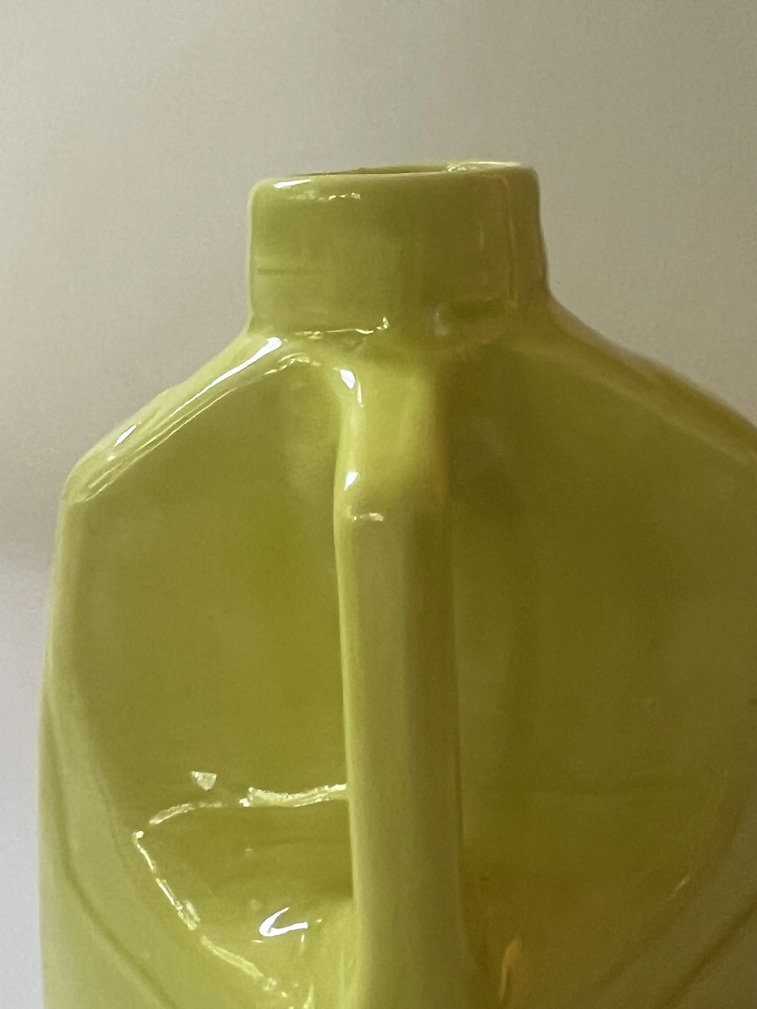 Close-up of integrated handle detail on glossy Pear ceramic vessel.
