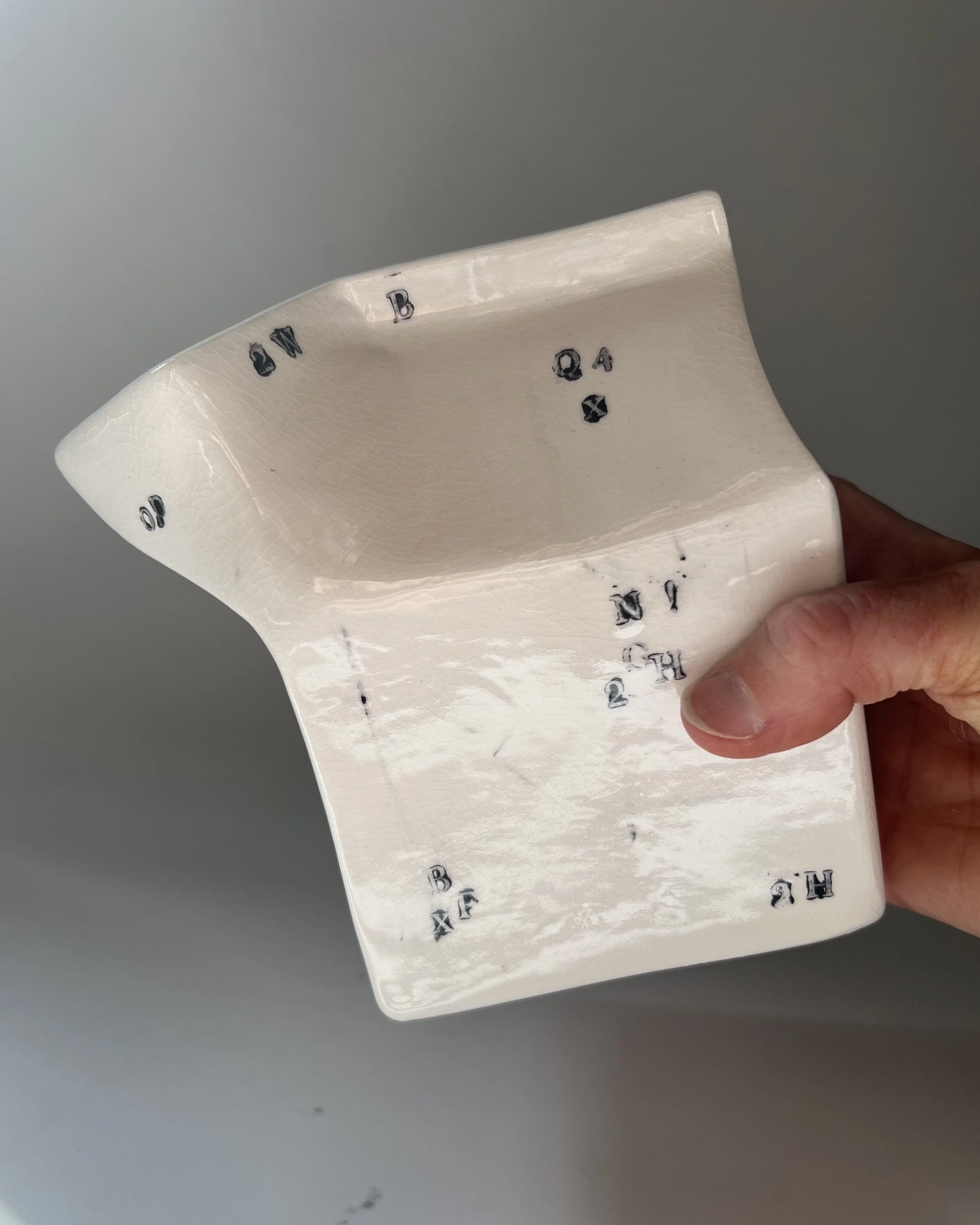 Hand holding a contemporary porcelain milk carton to show scale and proportions.