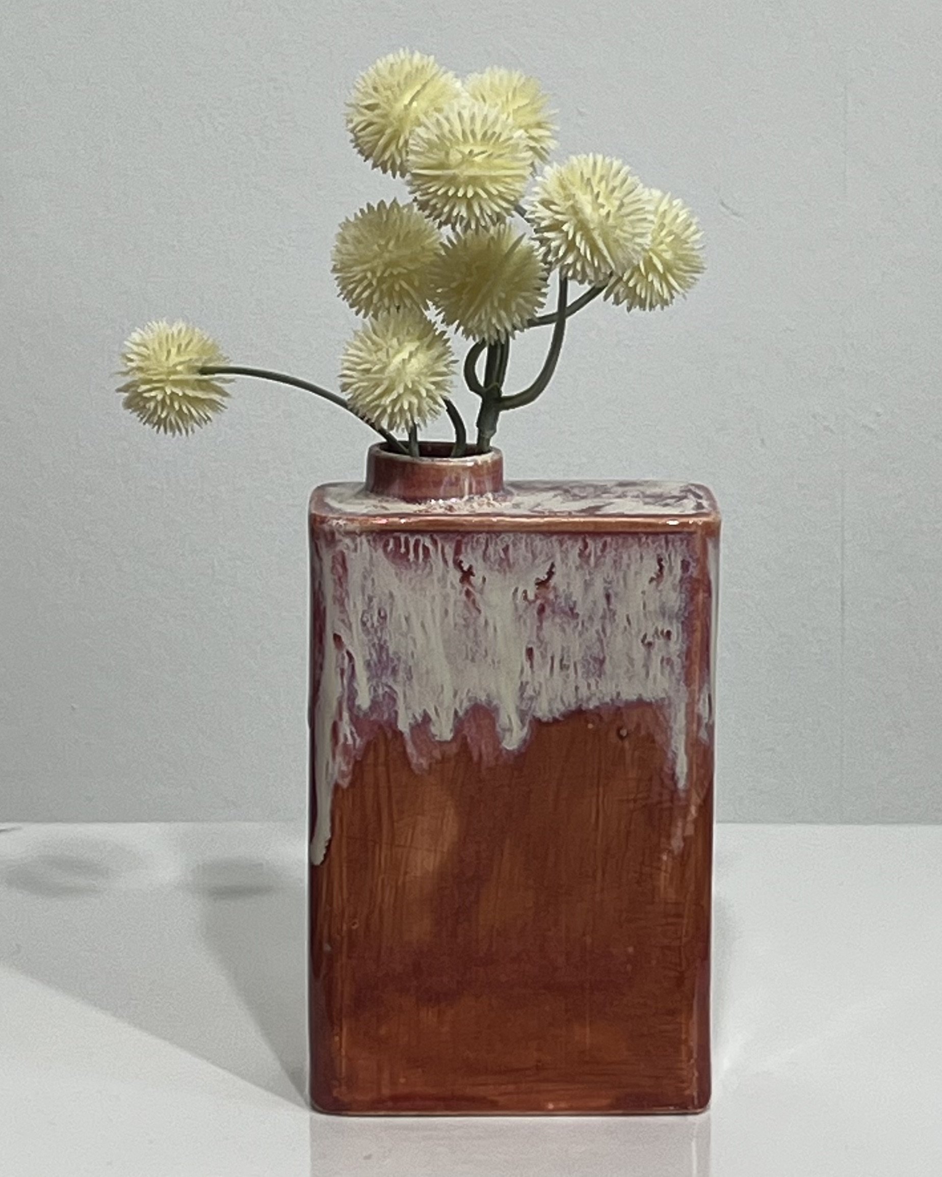 Handbuilt ceramic carton sculpture with flowers, finished in Chun Plum and Light Flux glaze