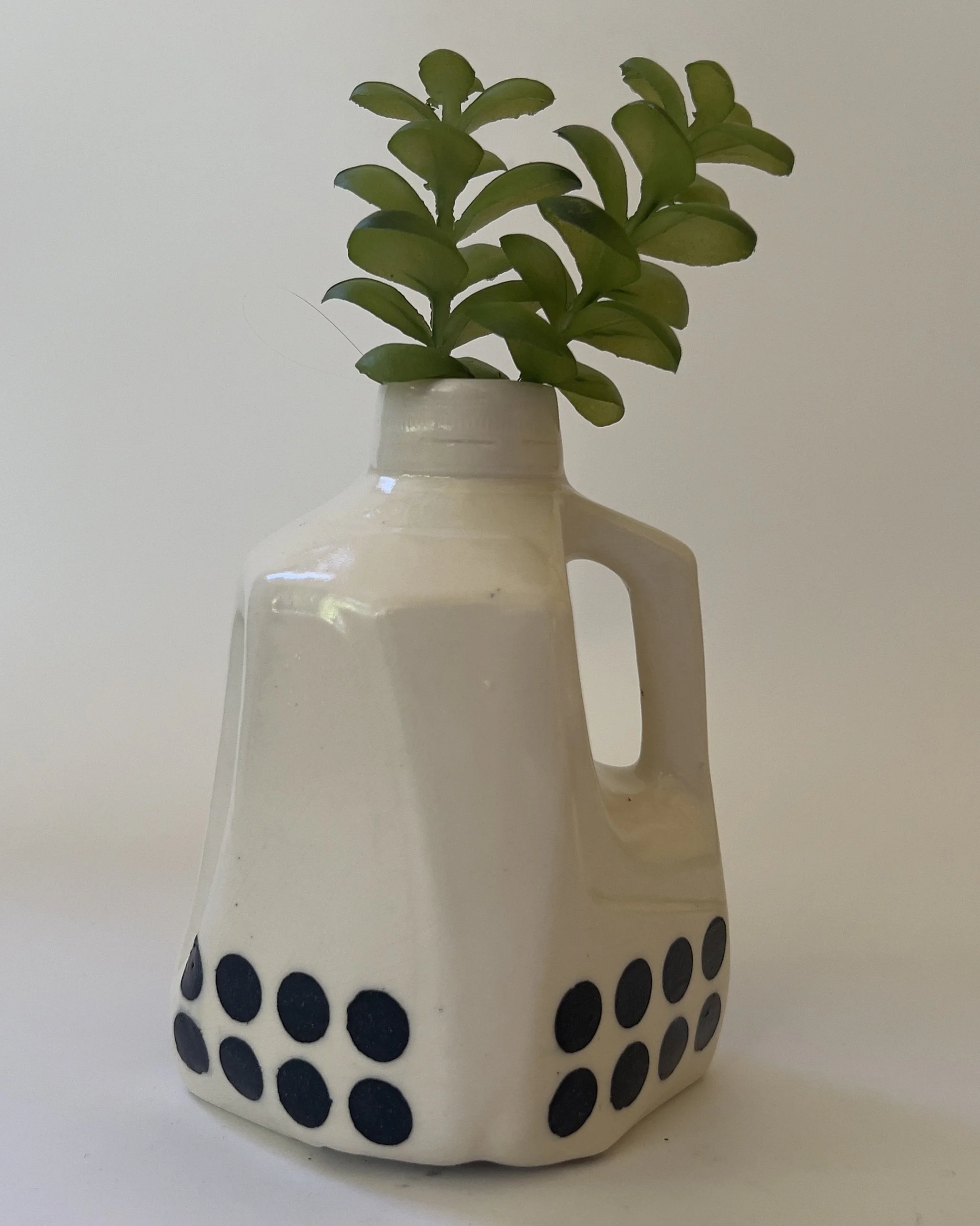 Ceramic milk jug vessel styled with greenery