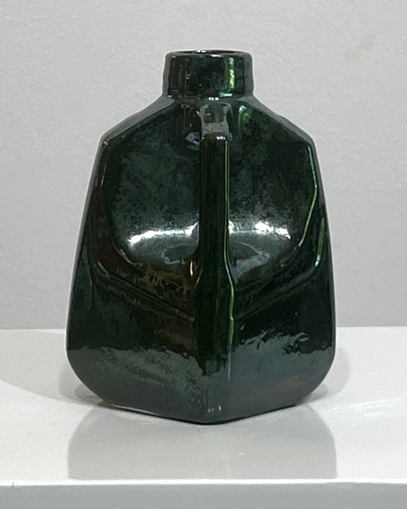 Rear three-quarter view of porcelain milk jug 26.48 highlighting the handle and glaze variation.
