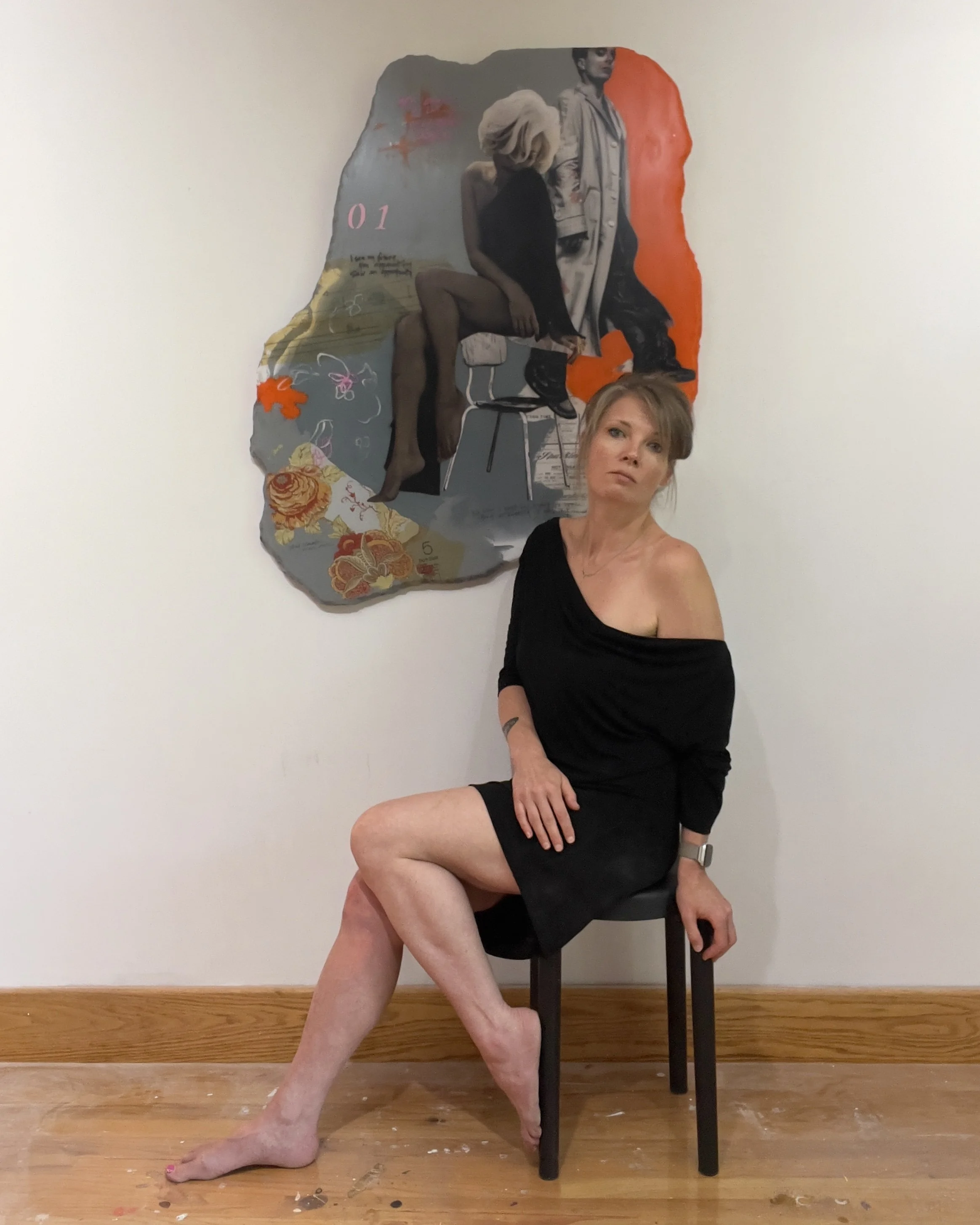 Artist Alissa Van Atta seated beside her original mixed media artwork Never Anyone's Number One in her studio.
