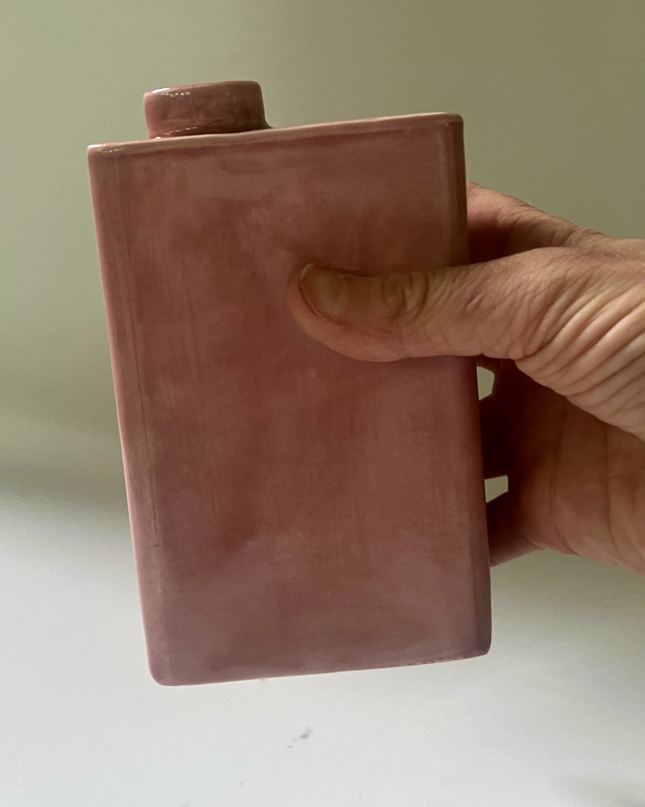 Handmade porcelain carton vase held in hand for scale, finished in Weeping Plum glaze.