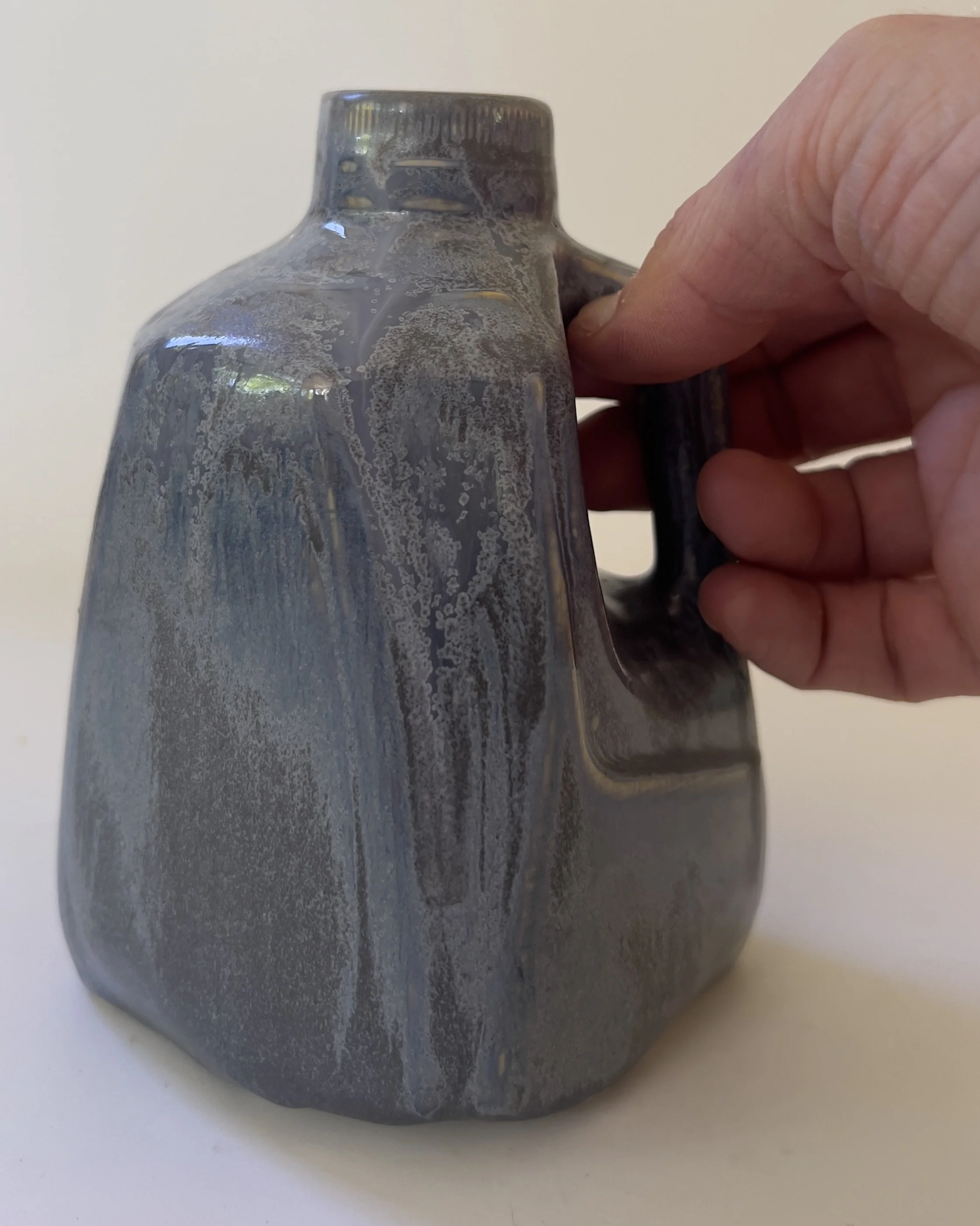 Scale reference showing size of handmade ceramic milk jug vase held in hand