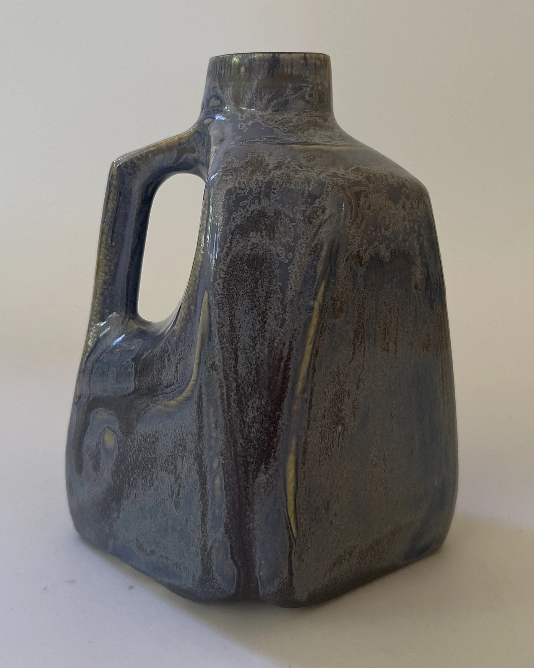 Side angle of sculptural stoneware milk jug with integrated handle and glossy Nimbus glaze