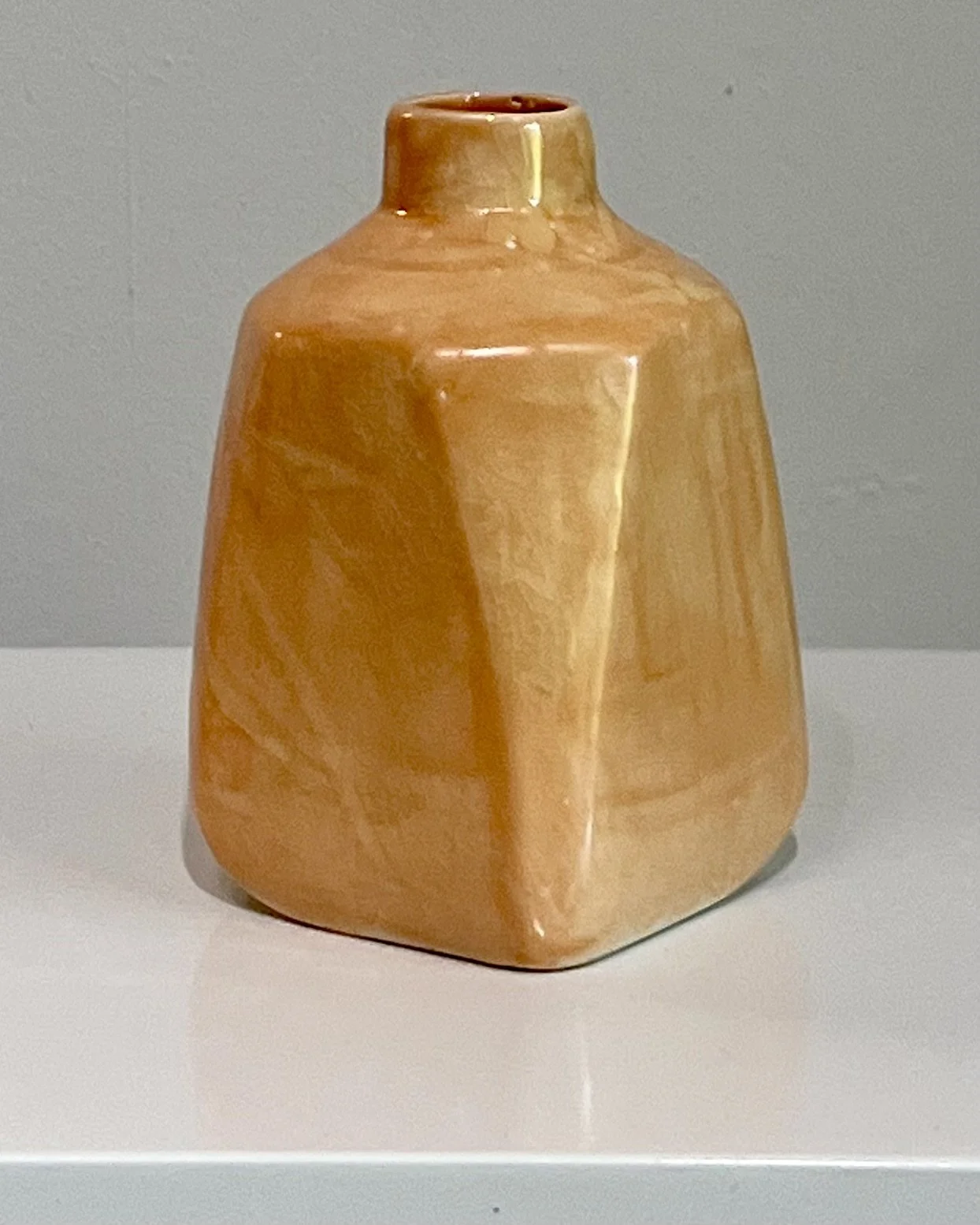 Side view of porcelain Milk Jug 26.53 glazed in Snow Drift over Tangelo