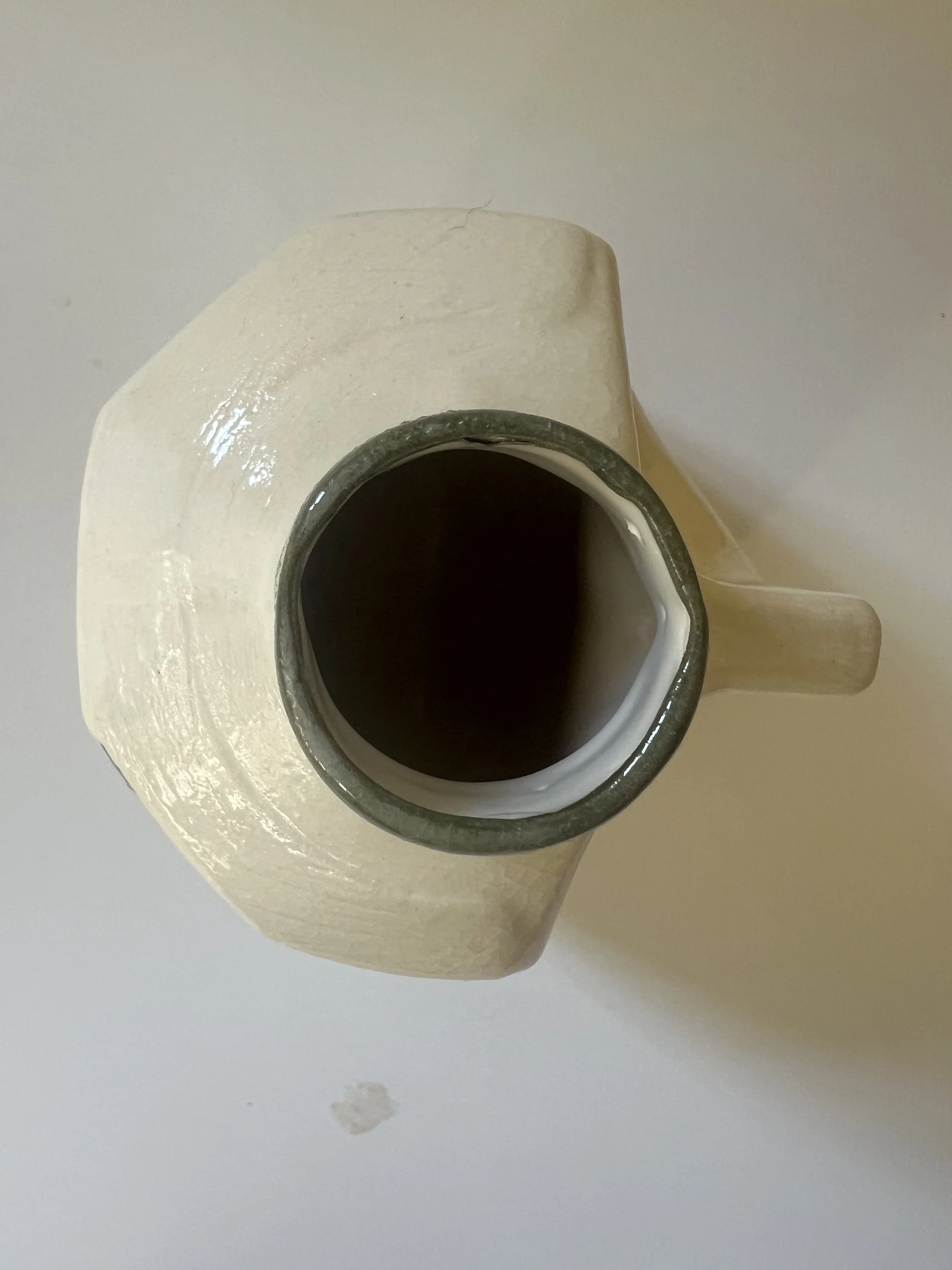 Top opening of porcelain milk jug vase showing glazed interior.