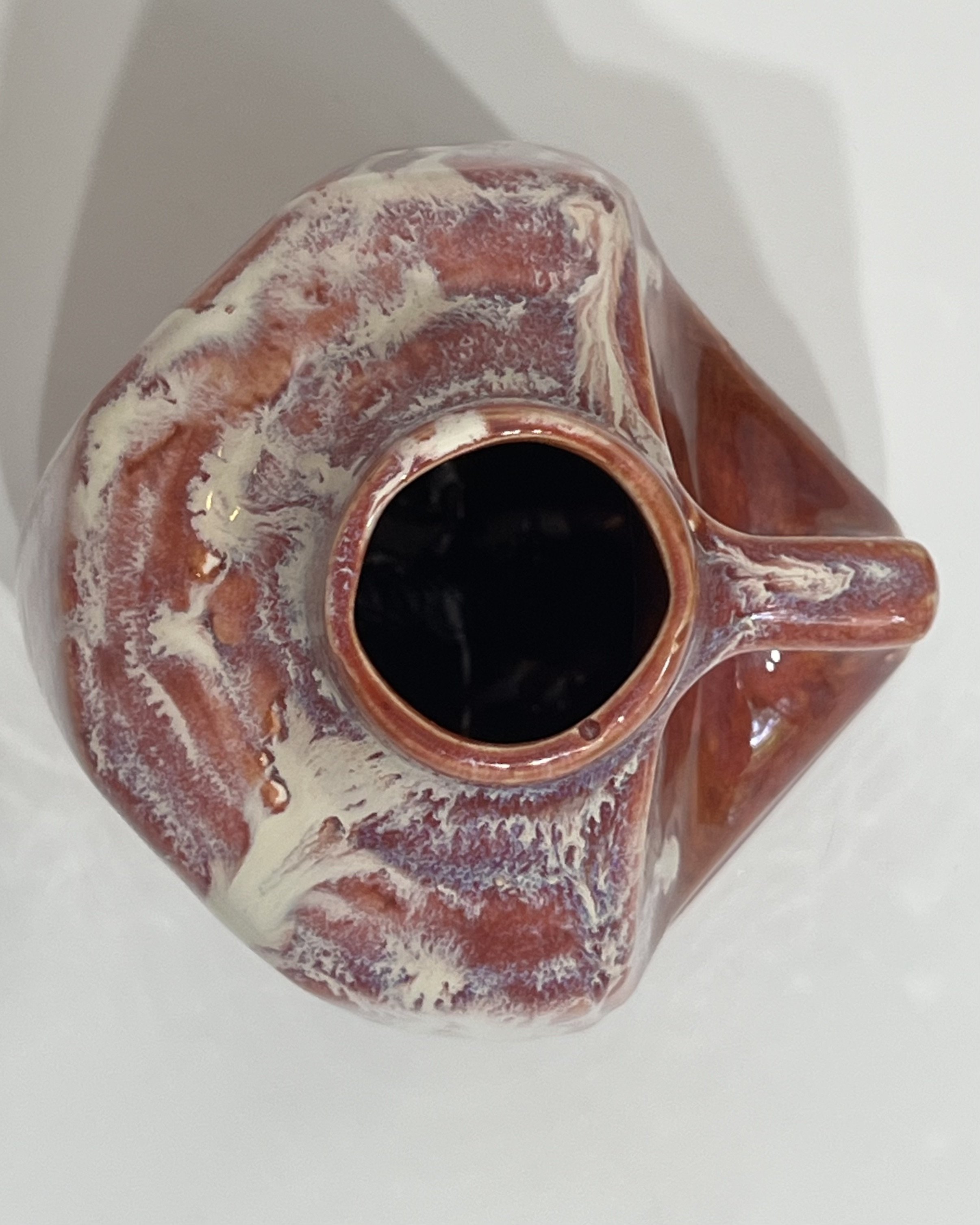 Overhead view of handmade porcelain milk jug showing its opening and glazed rim