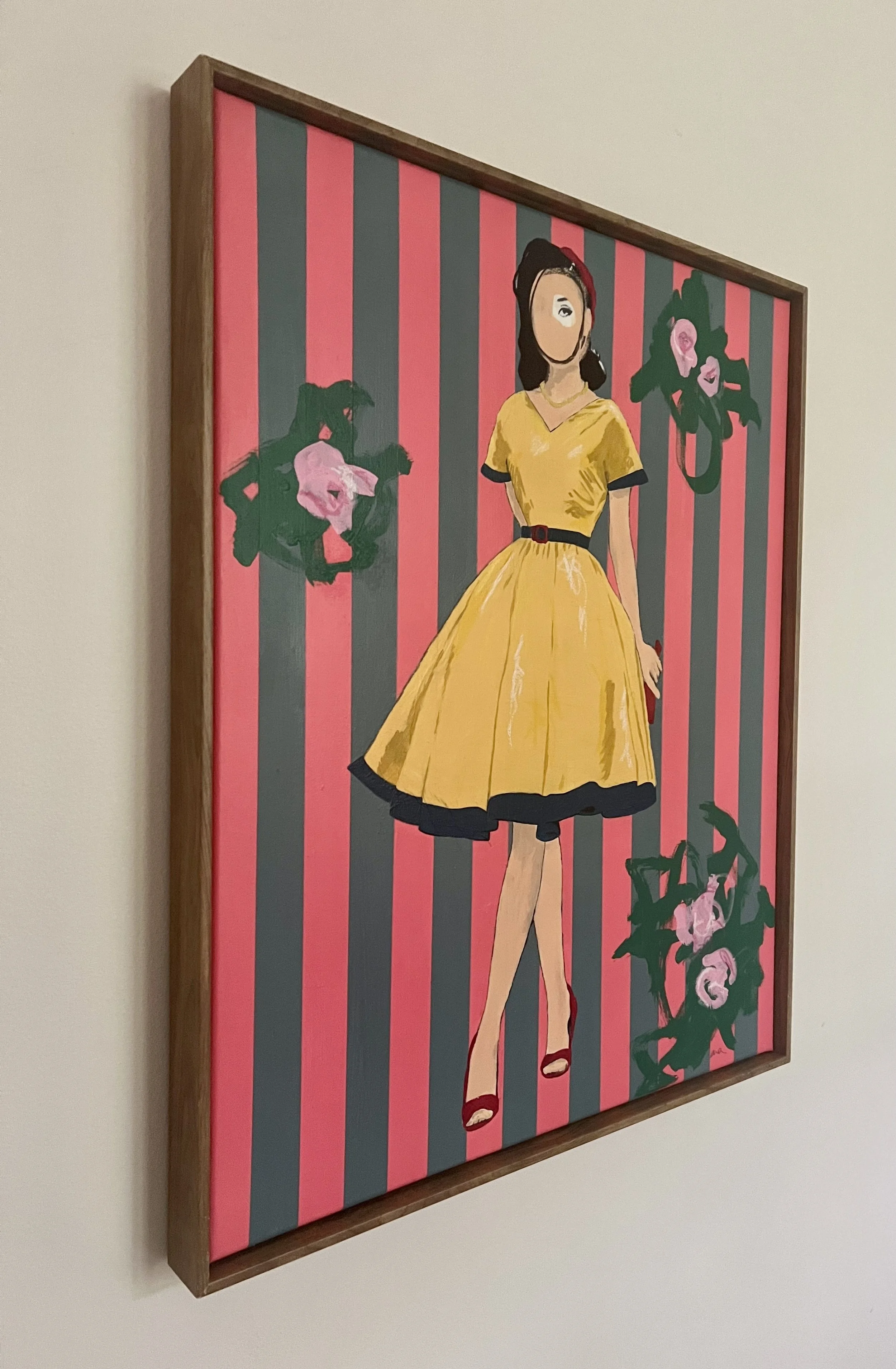 Angled photograph of Lady Wallflower, a framed original mixed media canvas painting by Alissa Van Atta, showing its black frame and colorful striped composition.