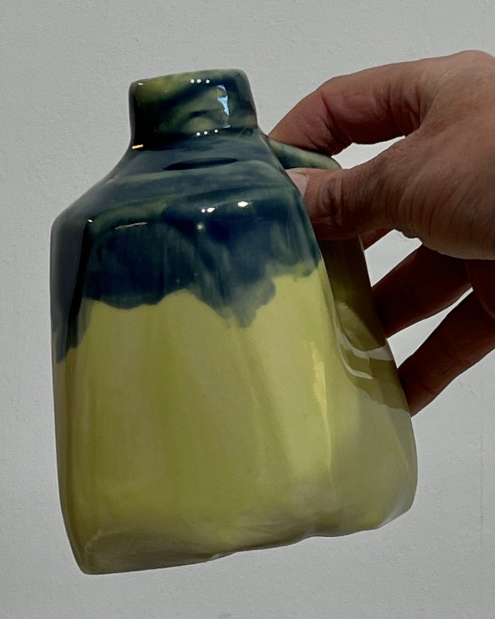 Handmade porcelain milk jug 26.123 held in hand to show its compact size