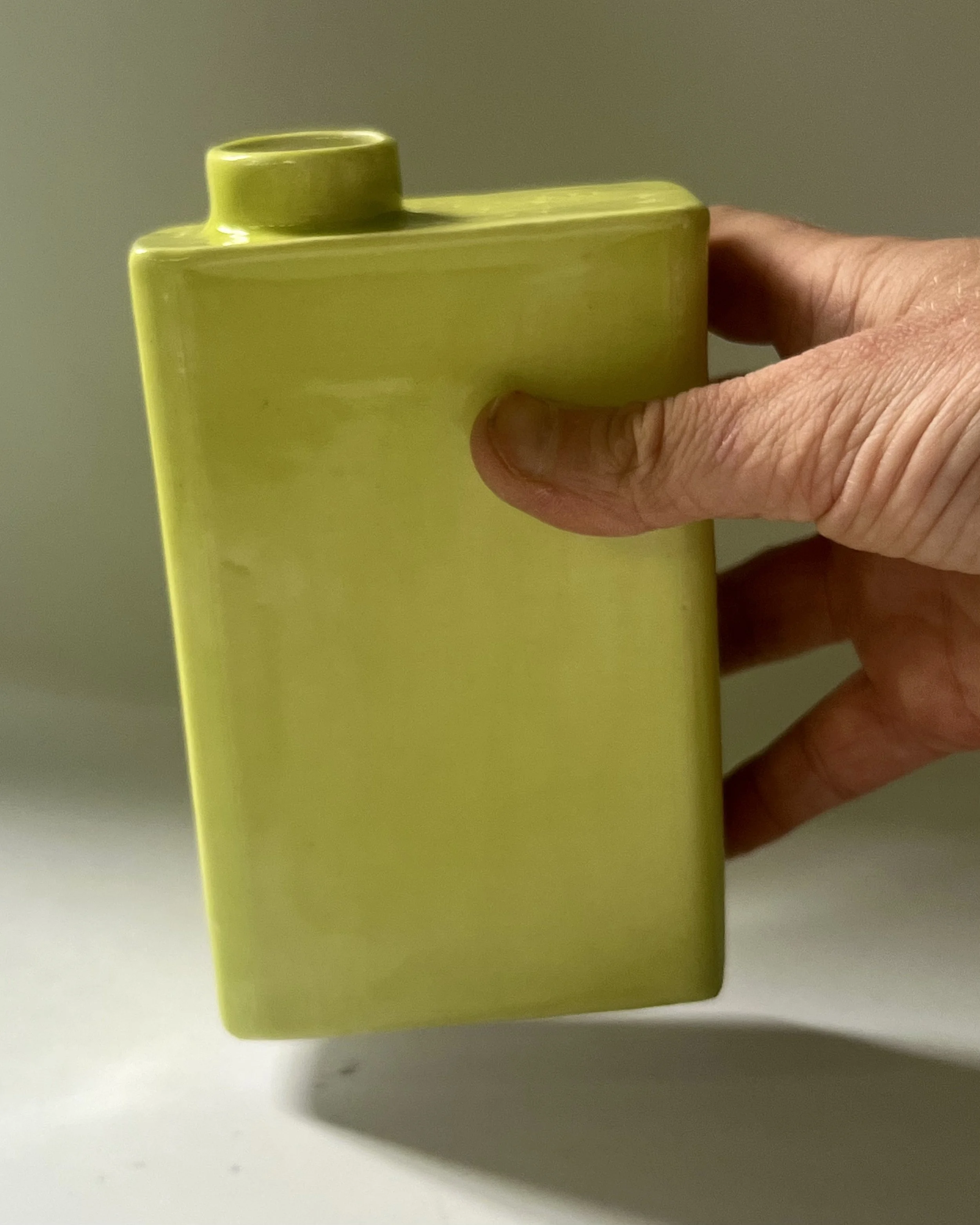 Pear glaze porcelain carton vase C26.9 shown in hand for scale