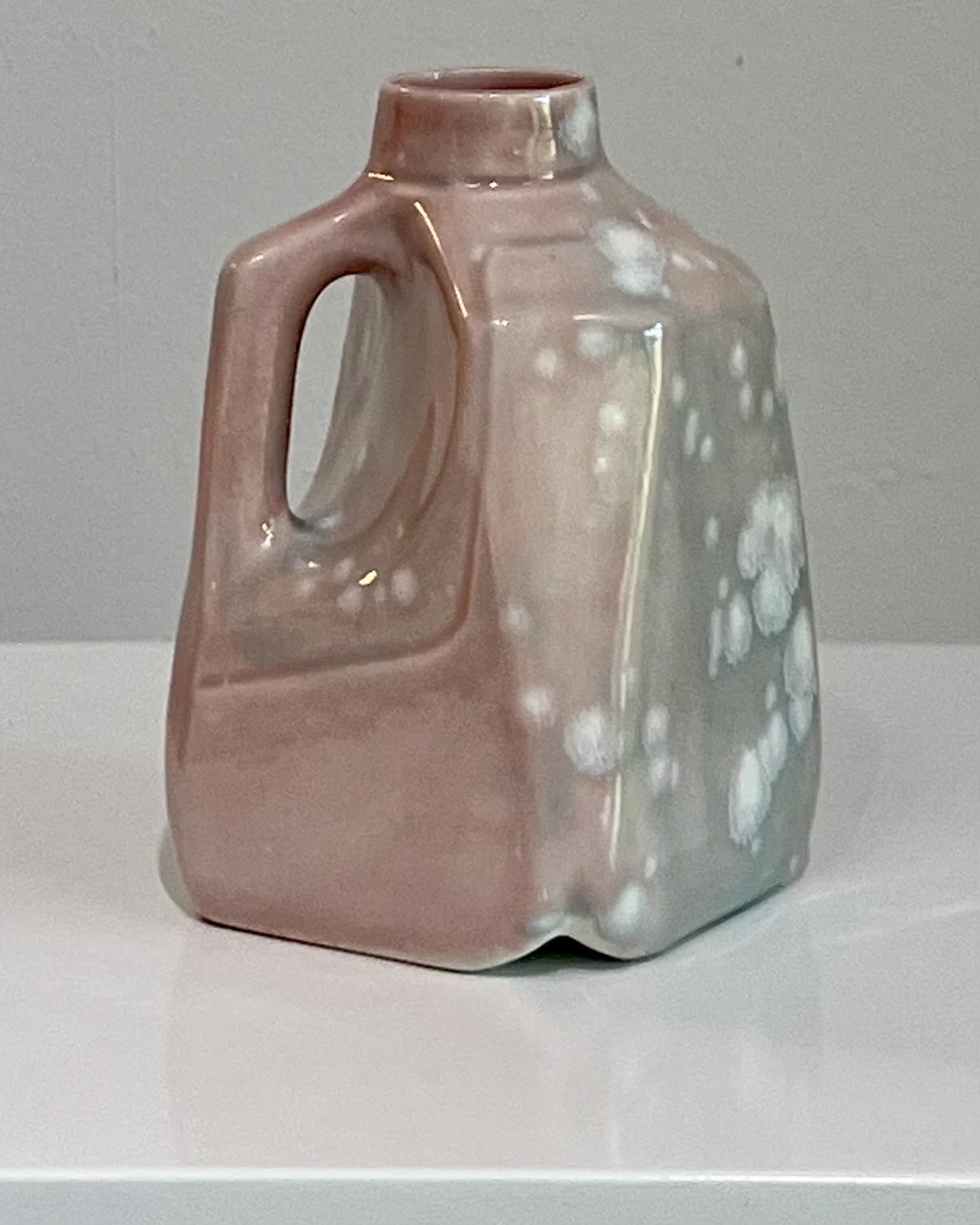 Back view of handmade porcelain milk jug showing crystalline glaze blooms and sculptural form.
