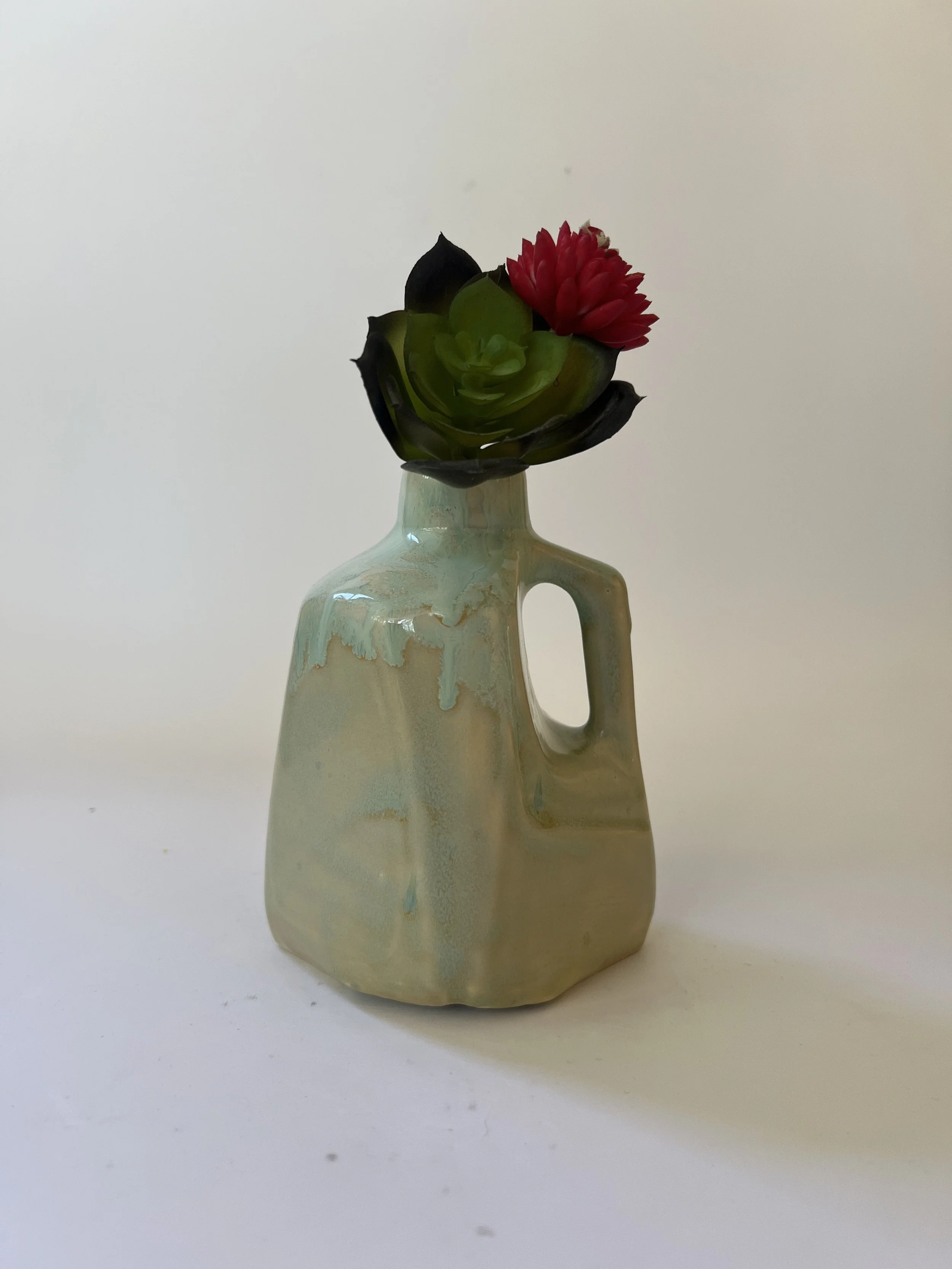 Handmade ceramic vase styled with succulent and red flower