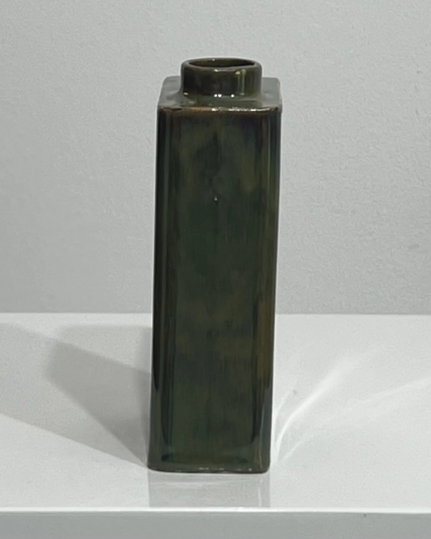Side view of Mood Ring porcelain carton vase showing layered green and bronze glaze