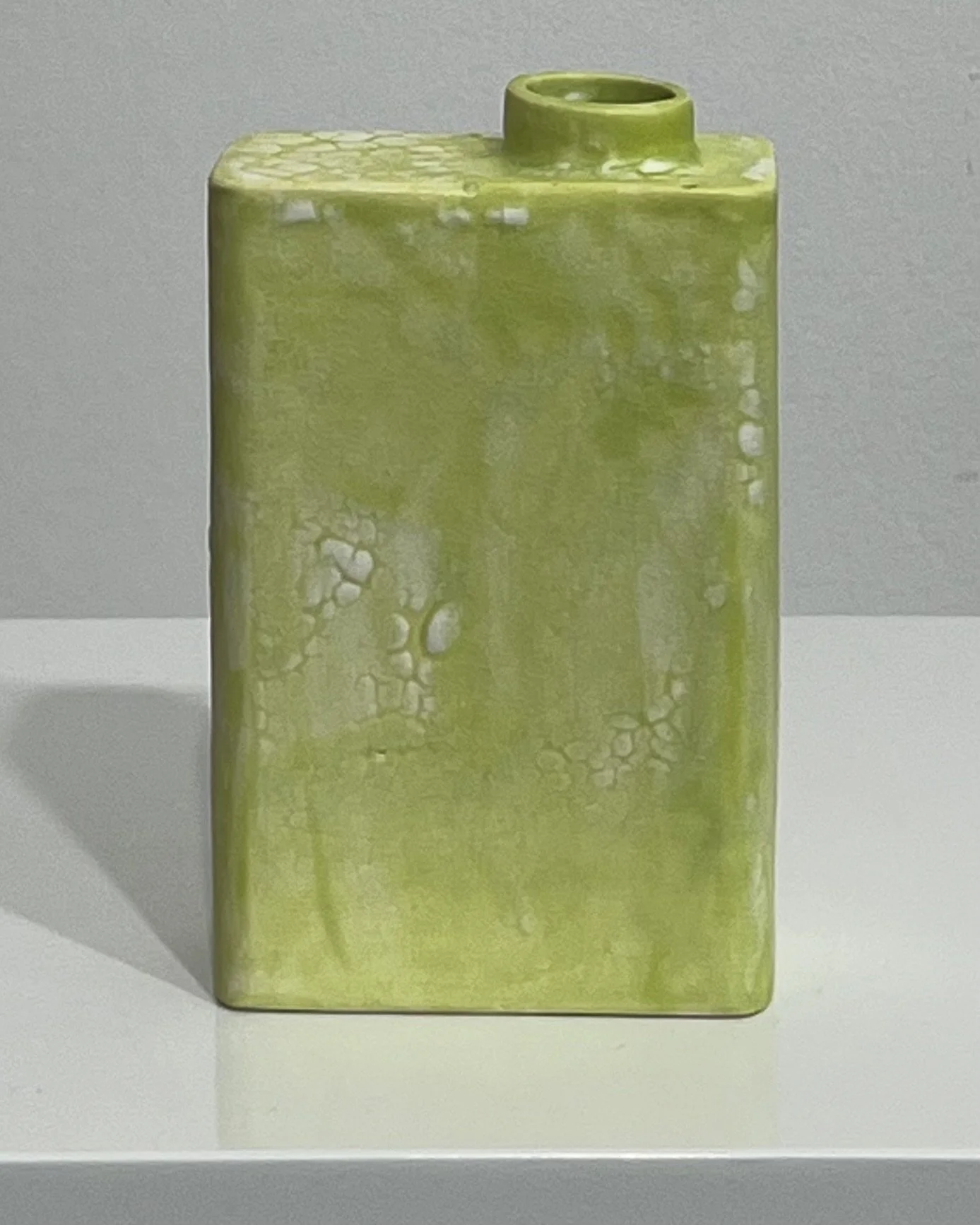 Back view of handmade chartreuse ceramic Carton showing organic glaze variations.