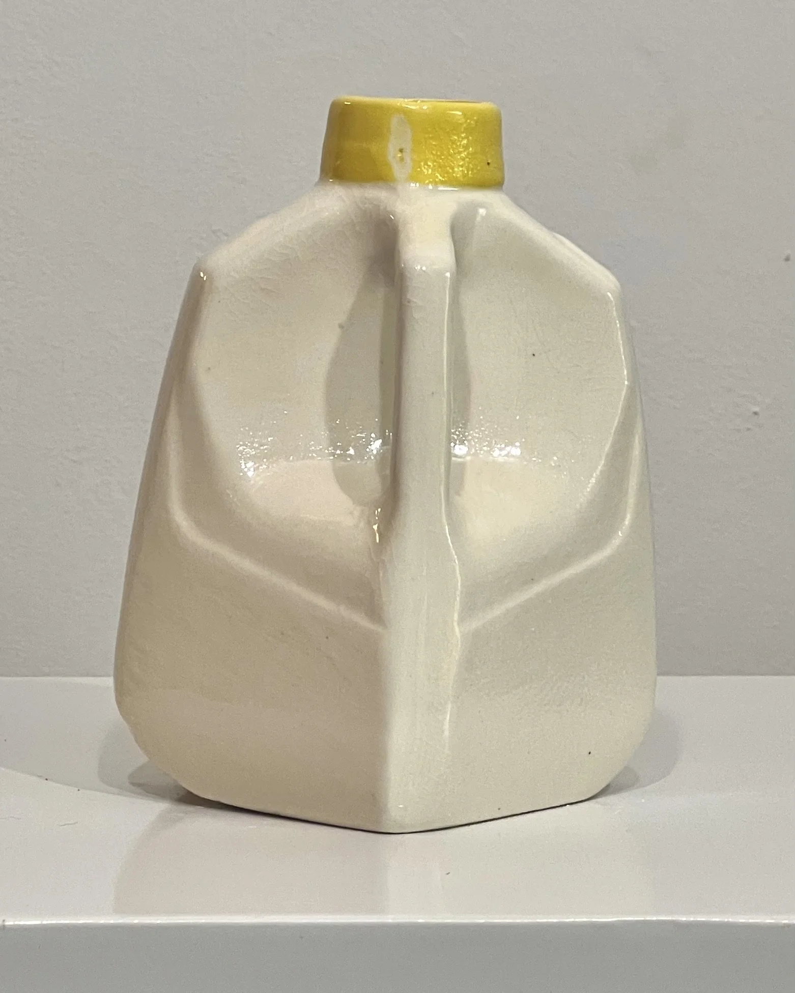 Back view of a one-of-a-kind yellow floral porcelain milk jug showing the continuous floral pattern.