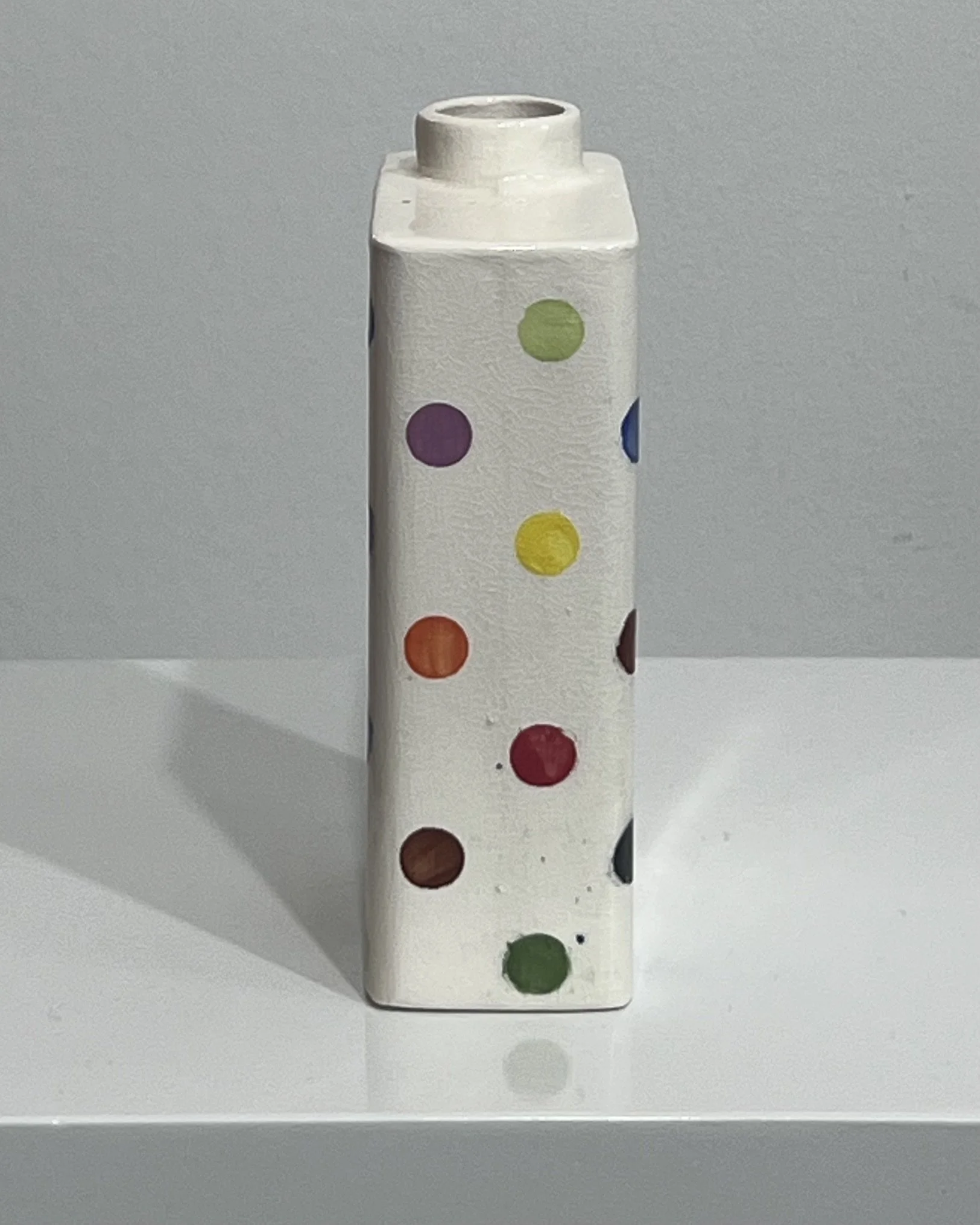 Opposite side view of multicolor polka dot porcelain carton vase