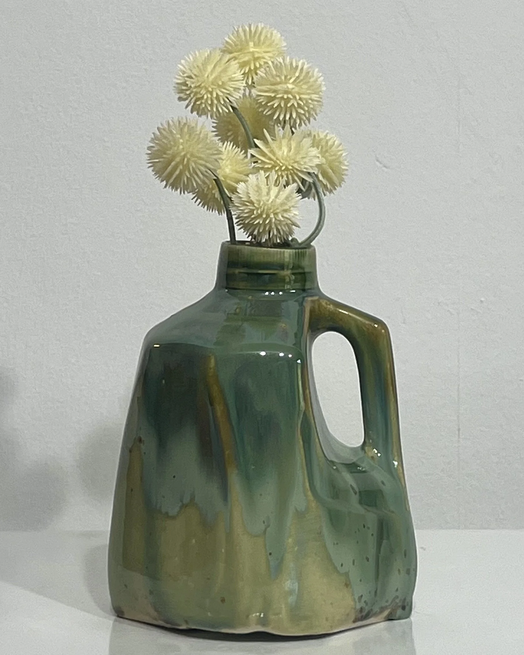 Handmade porcelain milk jug vase by Alissa Van Atta featuring layered Micro Jade and Seaweed glazes in rich green, teal, and olive tones.