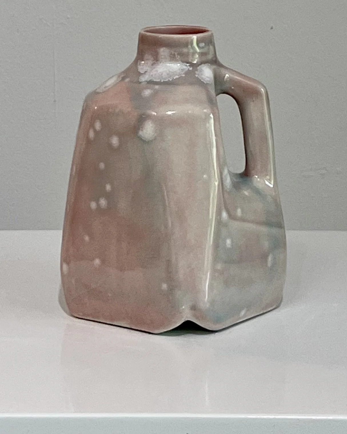 Front view of one-of-a-kind porcelain milk jug with soft blush and celadon crystalline glaze.