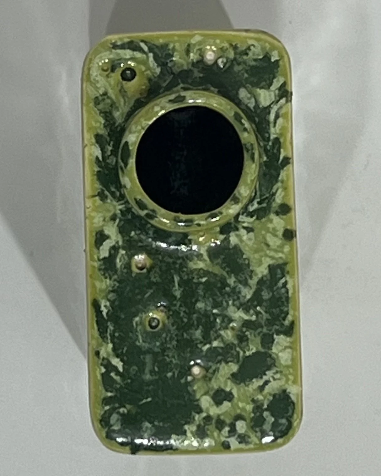 Overhead view of porcelain carton showing its circular opening and green glazed surface