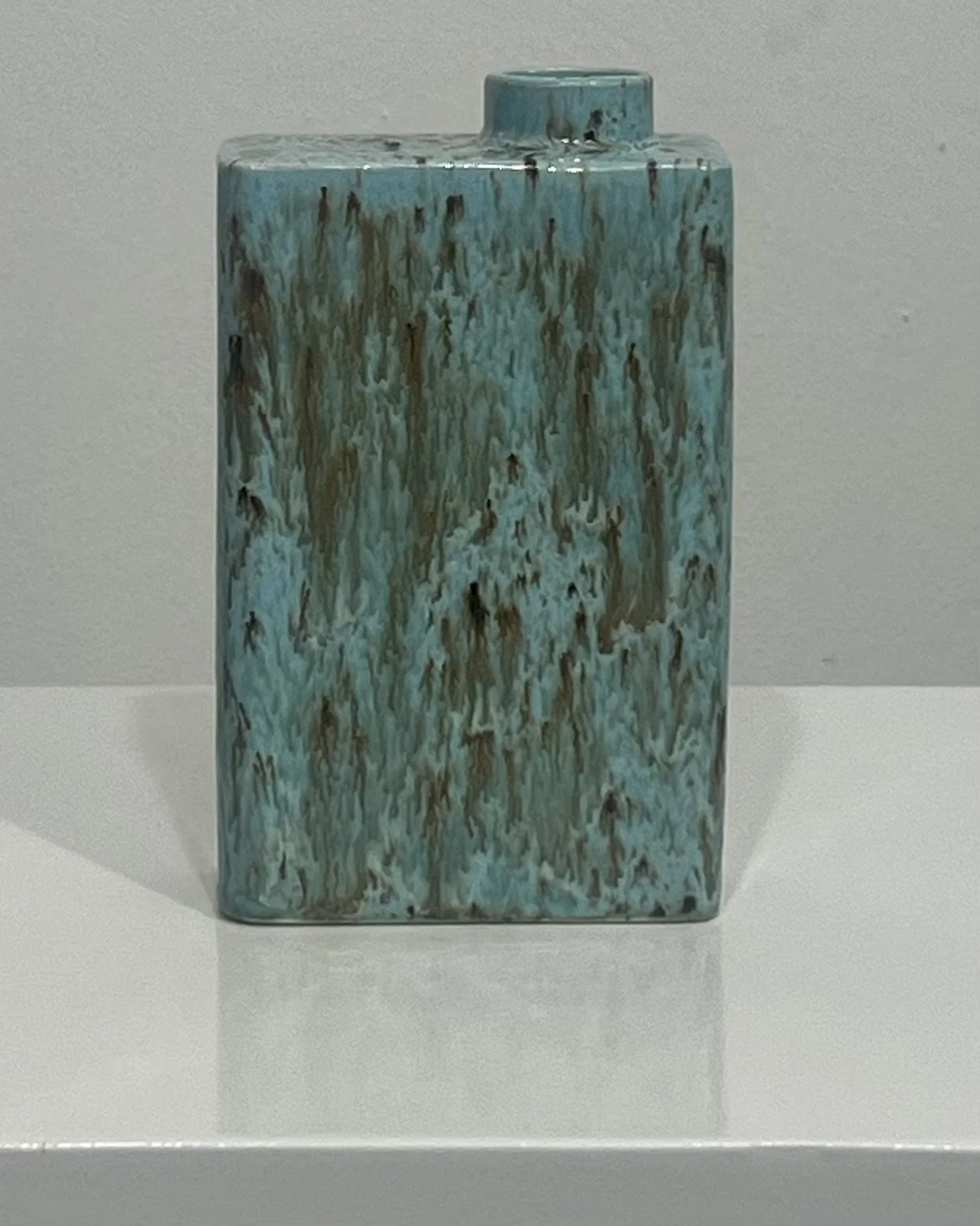 Back view of porcelain carton vase featuring layered turquoise blue and brown glaze effects.