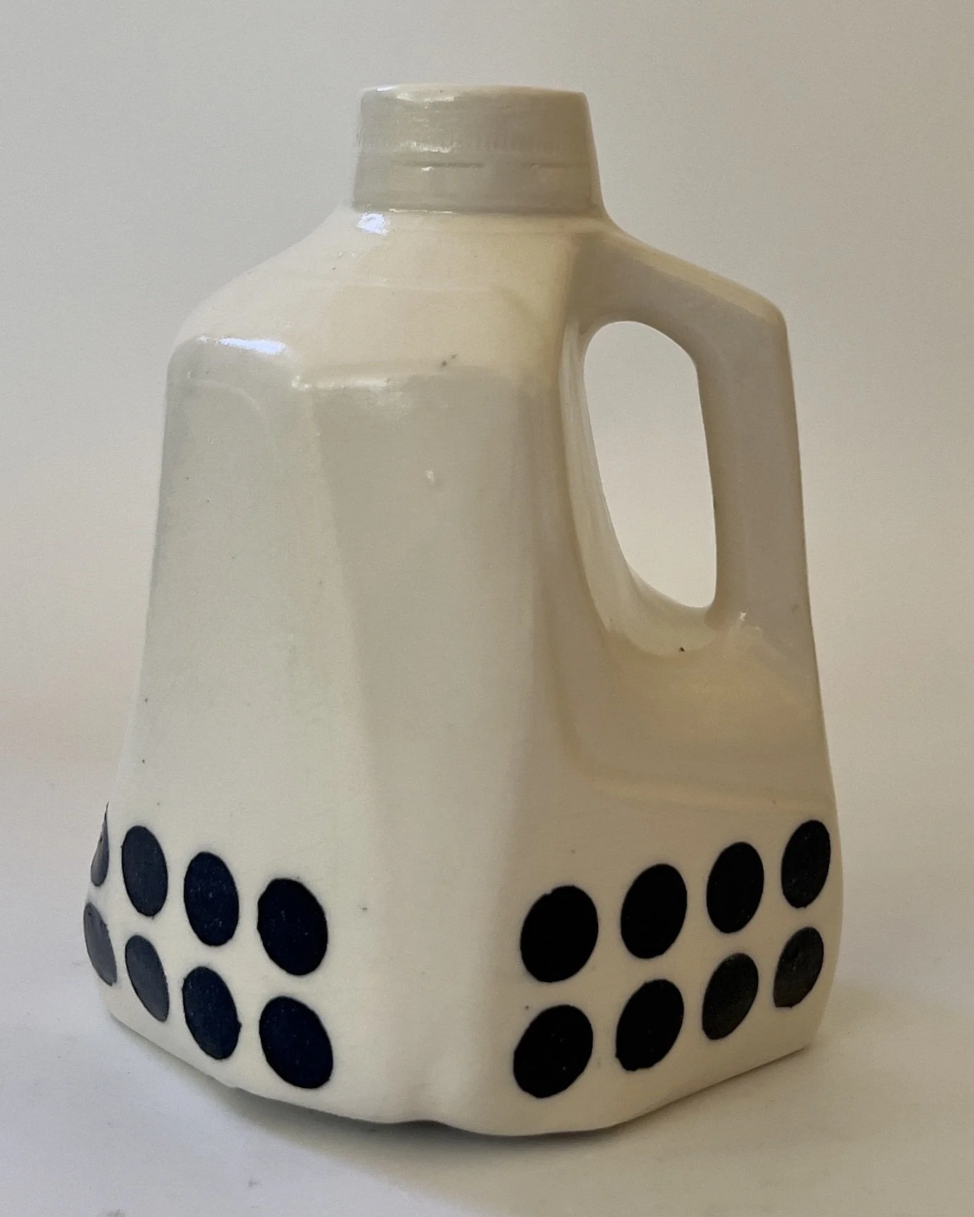 Handbuilt ceramic milk jug sculpture with black dot pattern