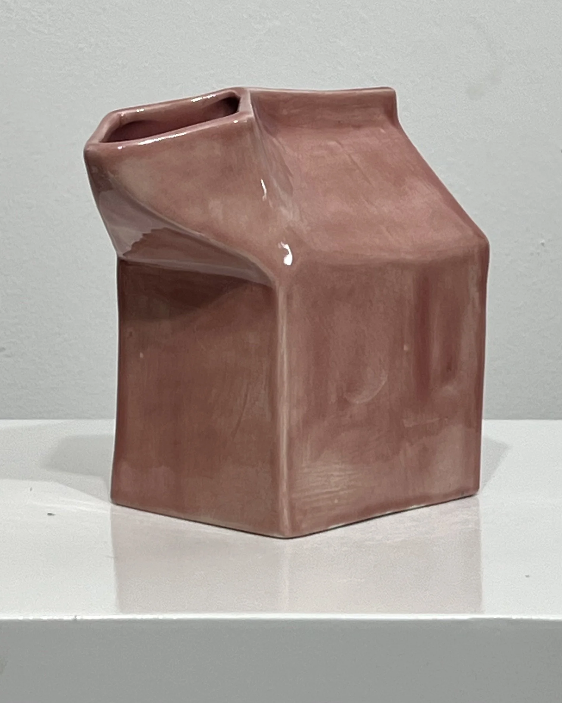 Back view of blush porcelain milk carton sculpture showing folded carton-inspired form and glossy ceramic surface.