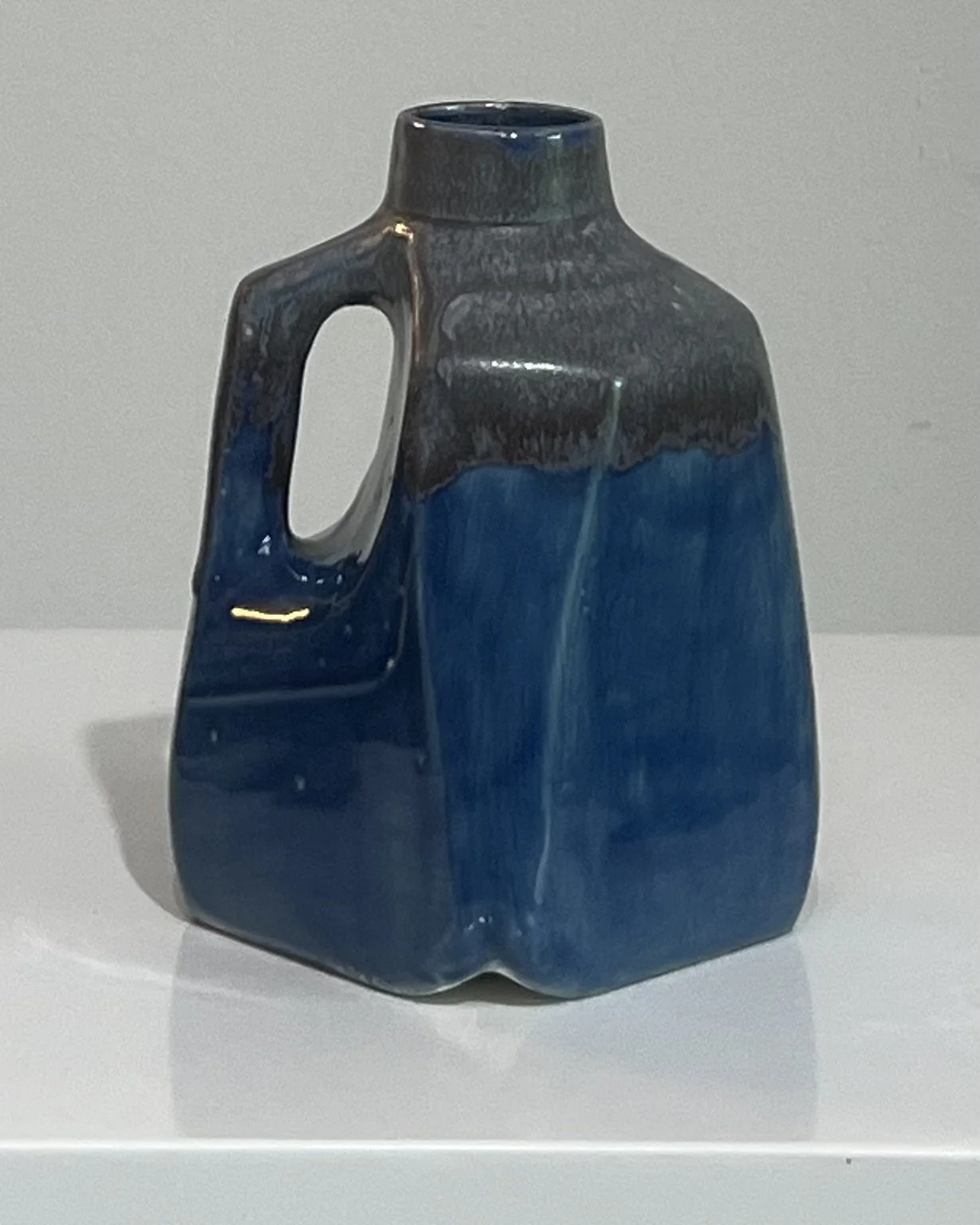 Side view of a one-of-a-kind porcelain milk jug featuring layered cobalt blue and smoky gray glazes.
