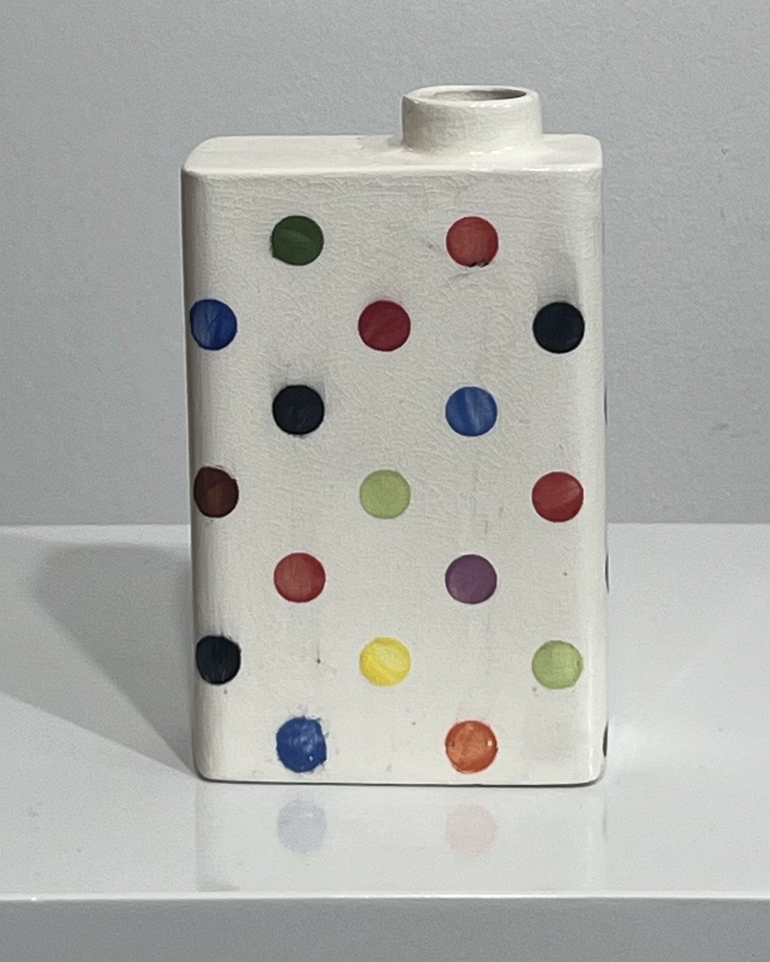 Back view of white porcelain carton vase with scattered colorful dots