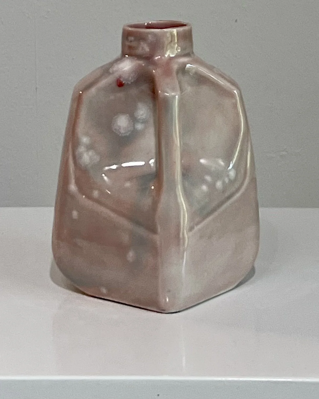 Three-quarter view highlighting the handle and layered Celadon Bloom over Cherry Blossom glaze.
