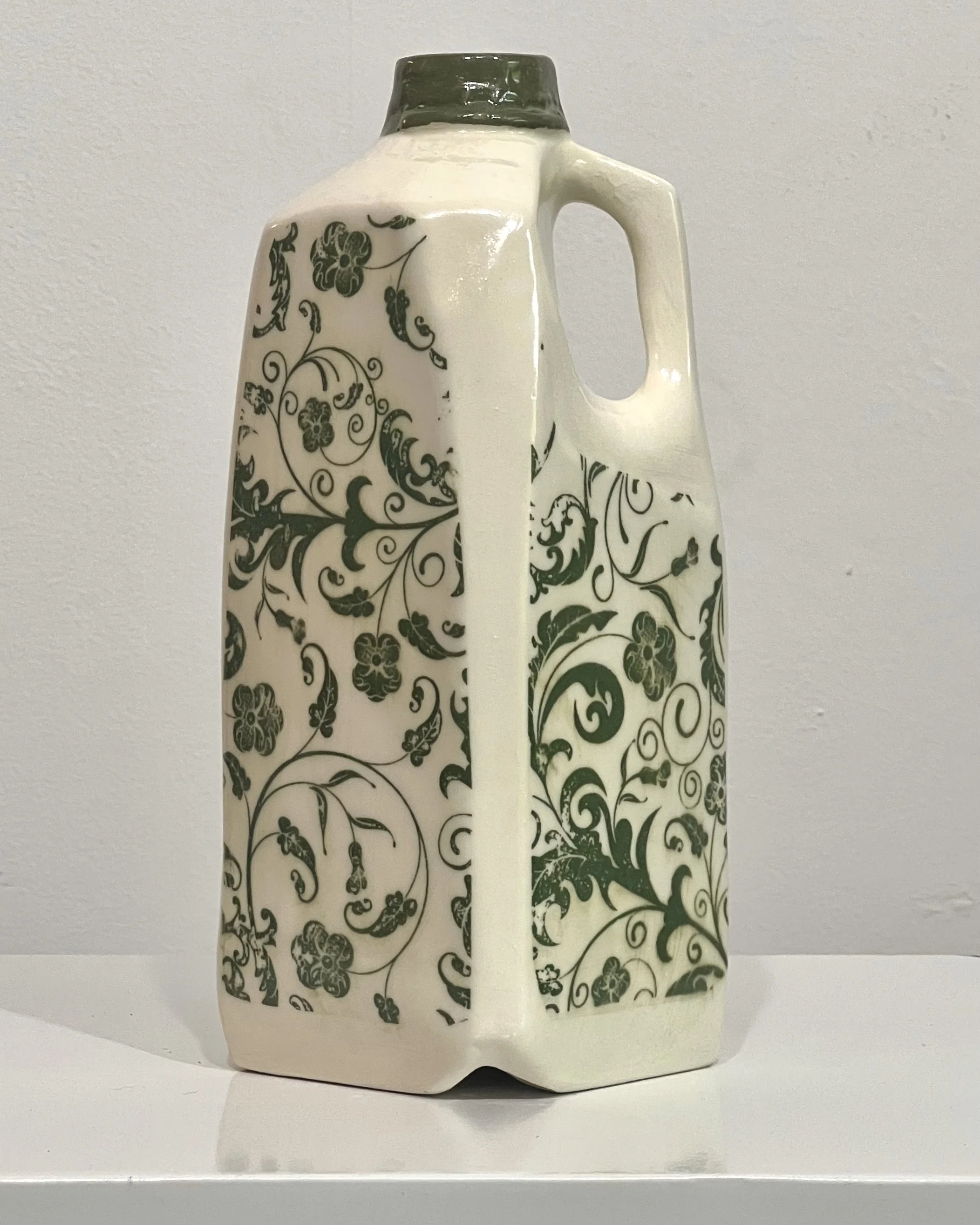 Handcrafted botanical tall porcelain milk jug with green botanical transfer beneath a glossy clear glaze.