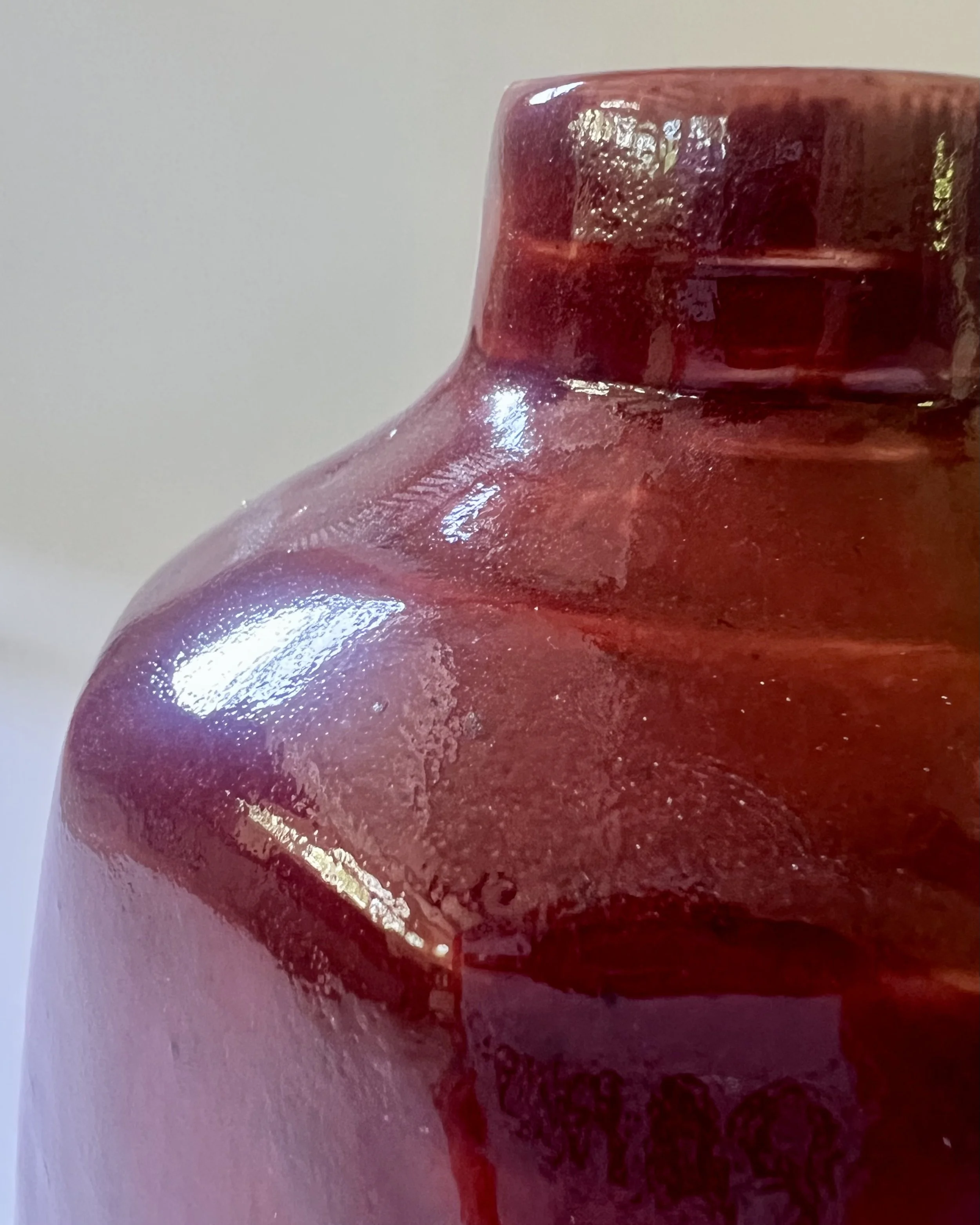 Detail of Deep Firebrick glaze on handmade porcelain milk jug vase