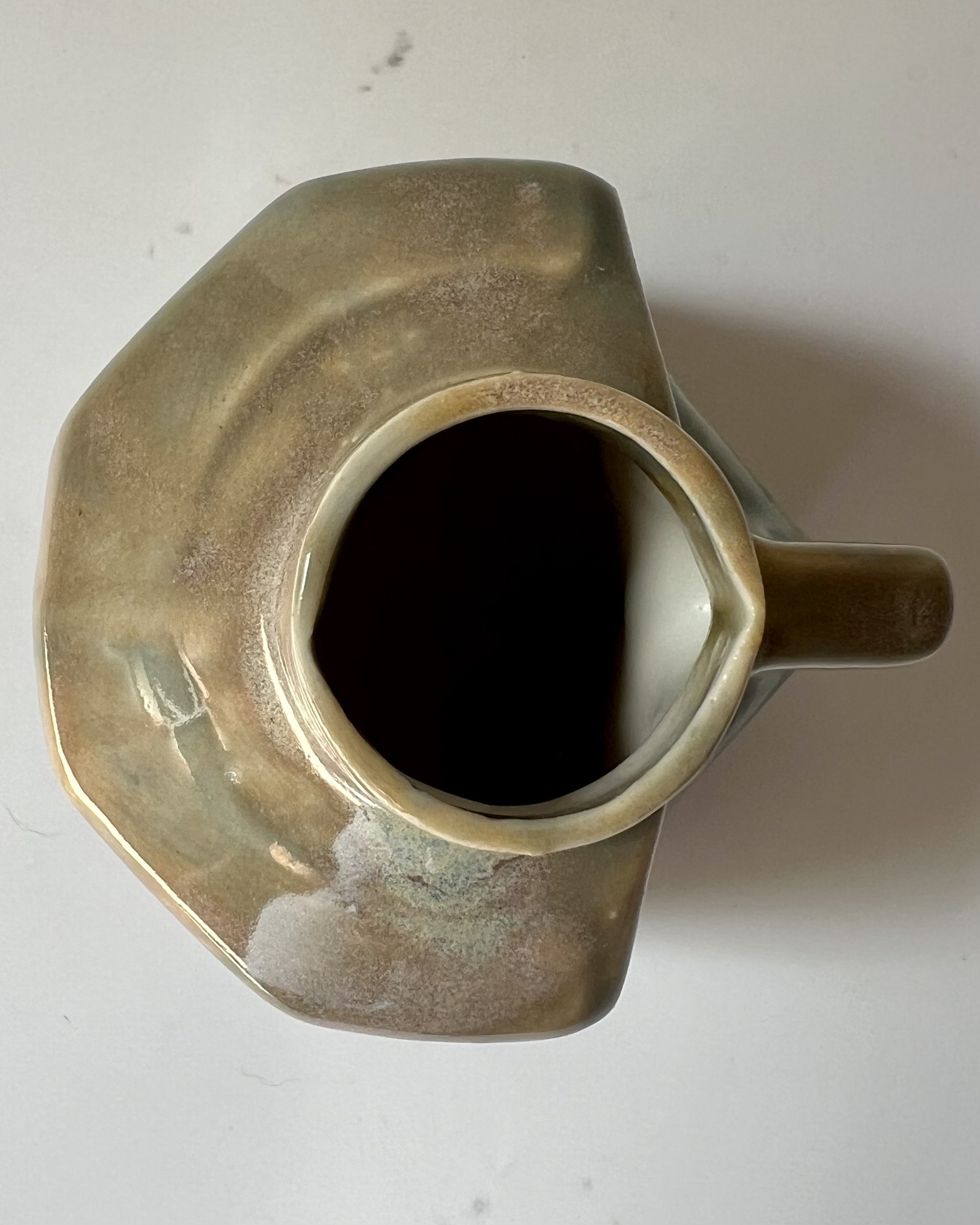 Top view of a handmade porcelain milk jug showing the opening and geometric form.