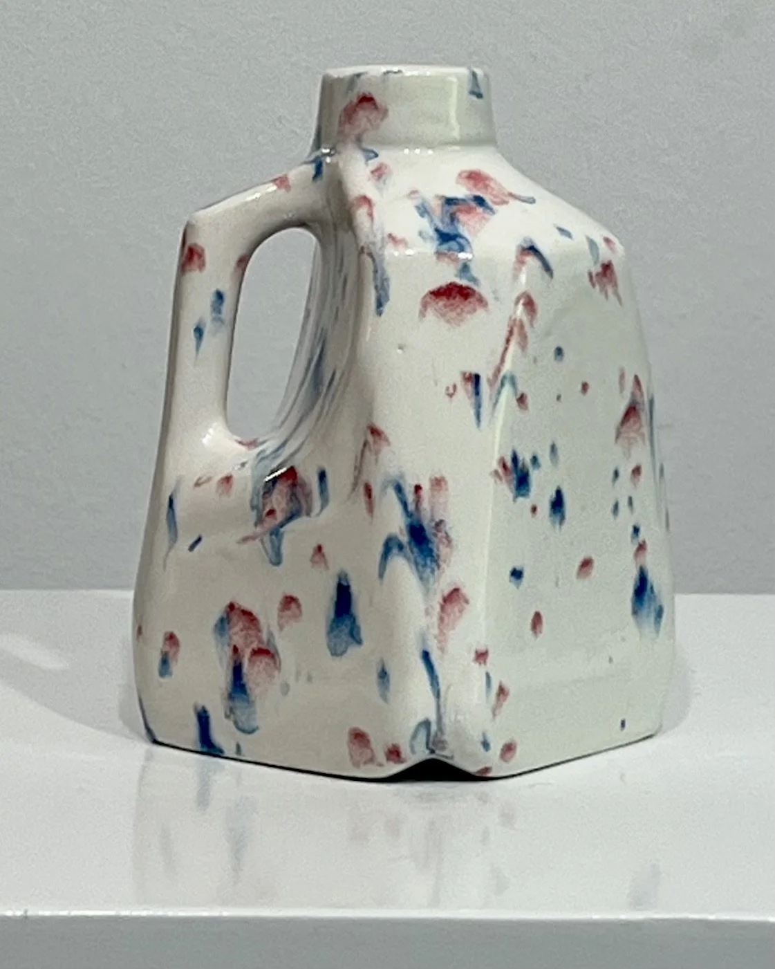 Right side view of Kaboom porcelain milk jug vase highlighting the handle and flowing glaze pattern.