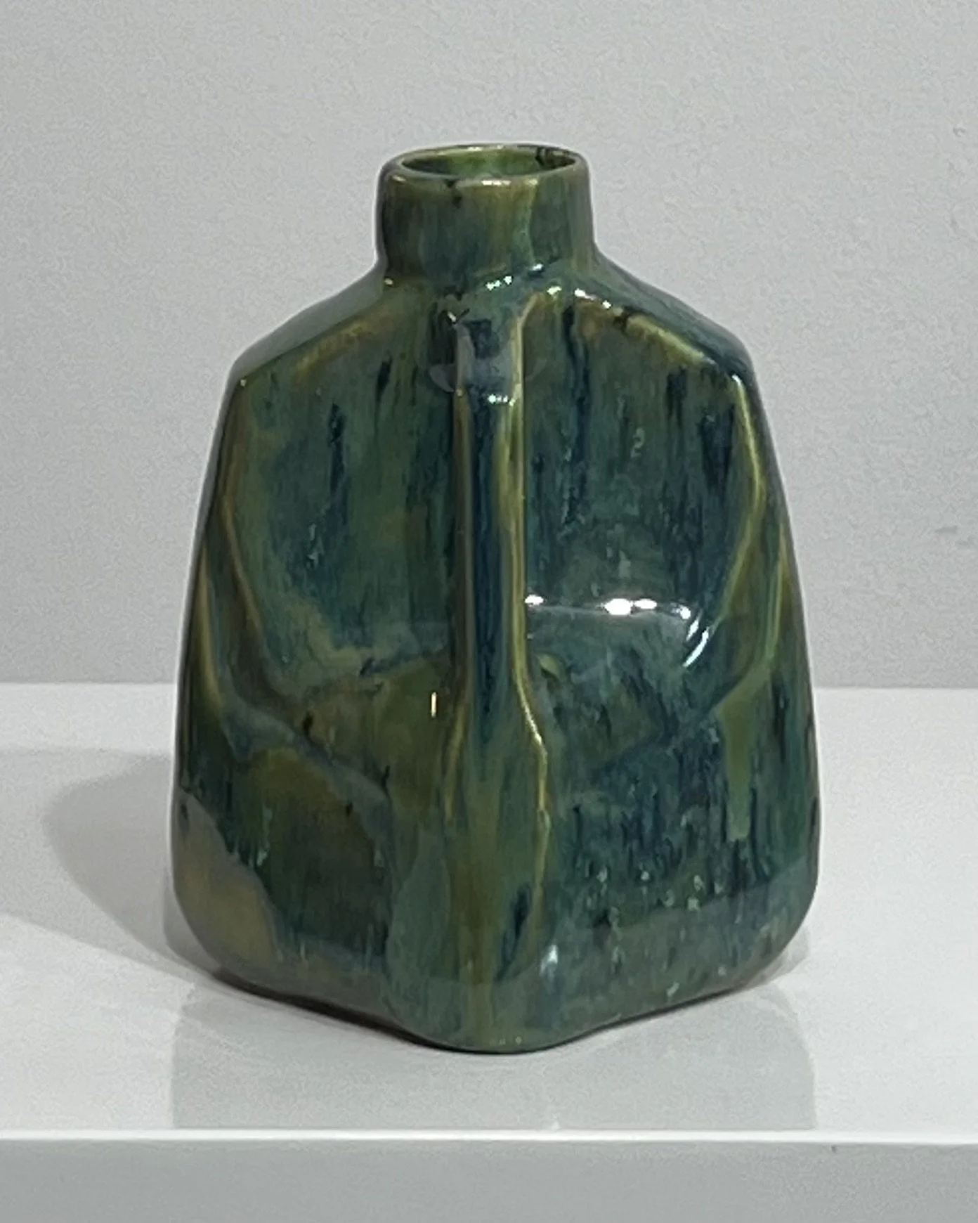 Right-side view of porcelain milk jug showing its handle and rich blue-green glaze variations.