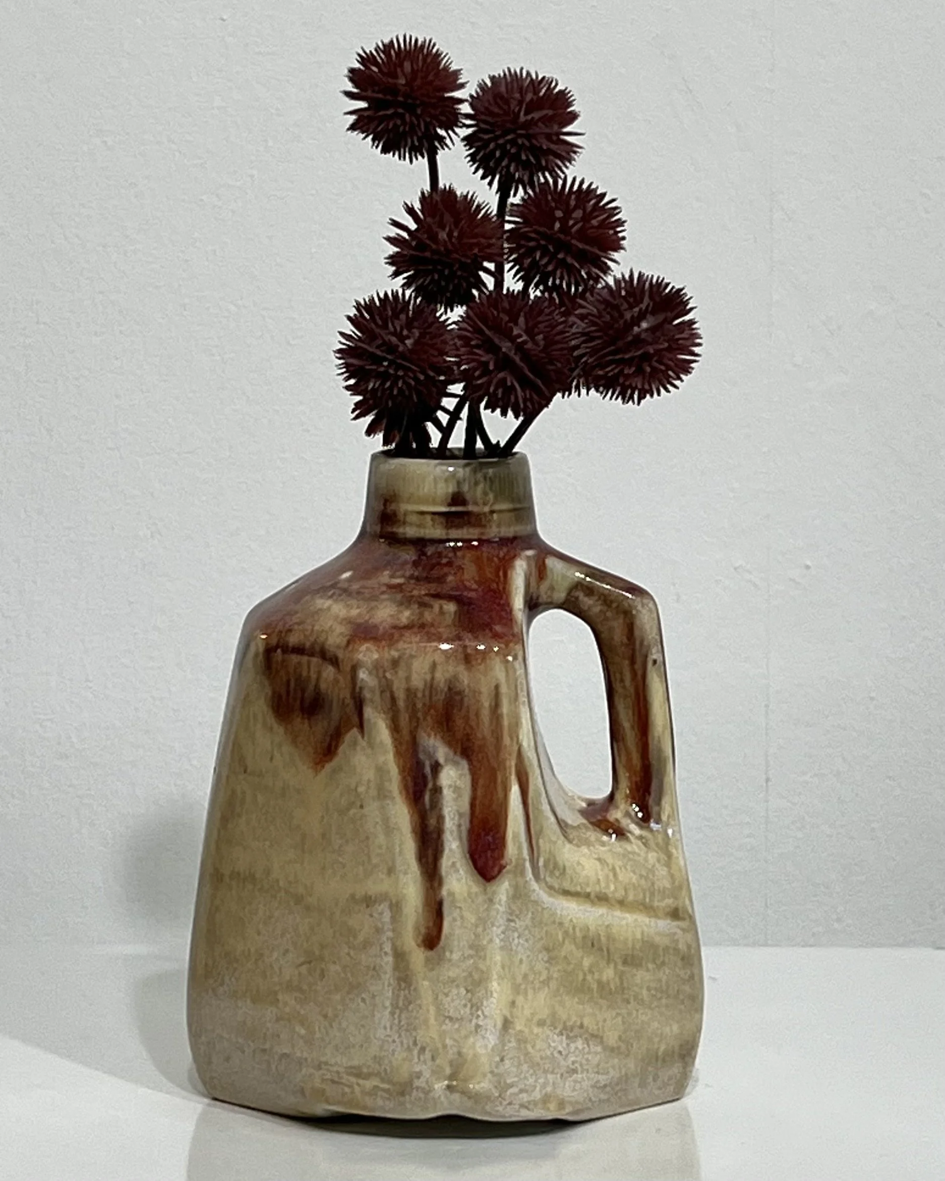 Handmade porcelain milk jug vase by Alissa Van Atta featuring Oatmeal and Chun Plum glazes in cream and burgundy, styled with dark red berry stems.