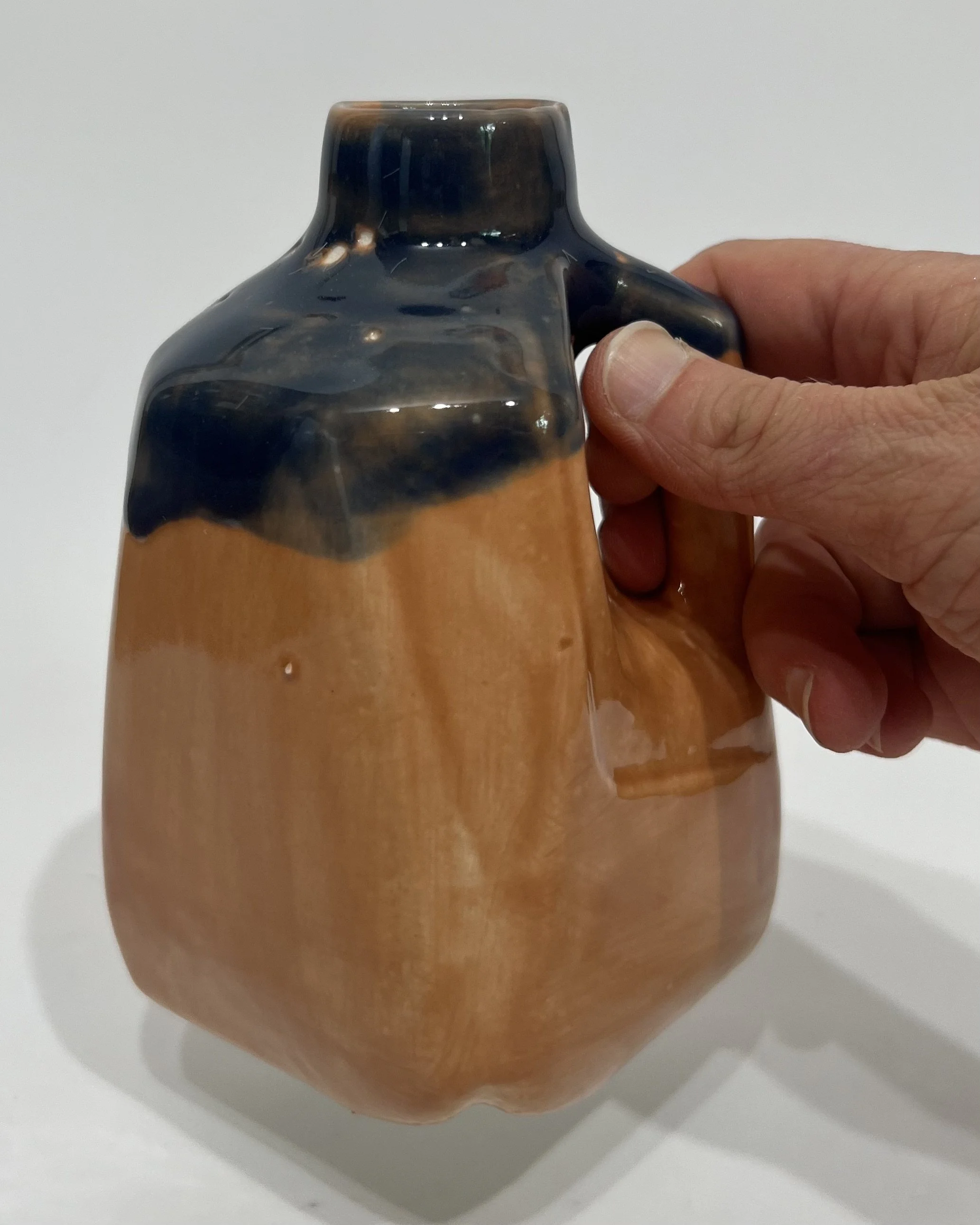Sandalwood and Deep Sea porcelain milk jug vase held in hand for scale