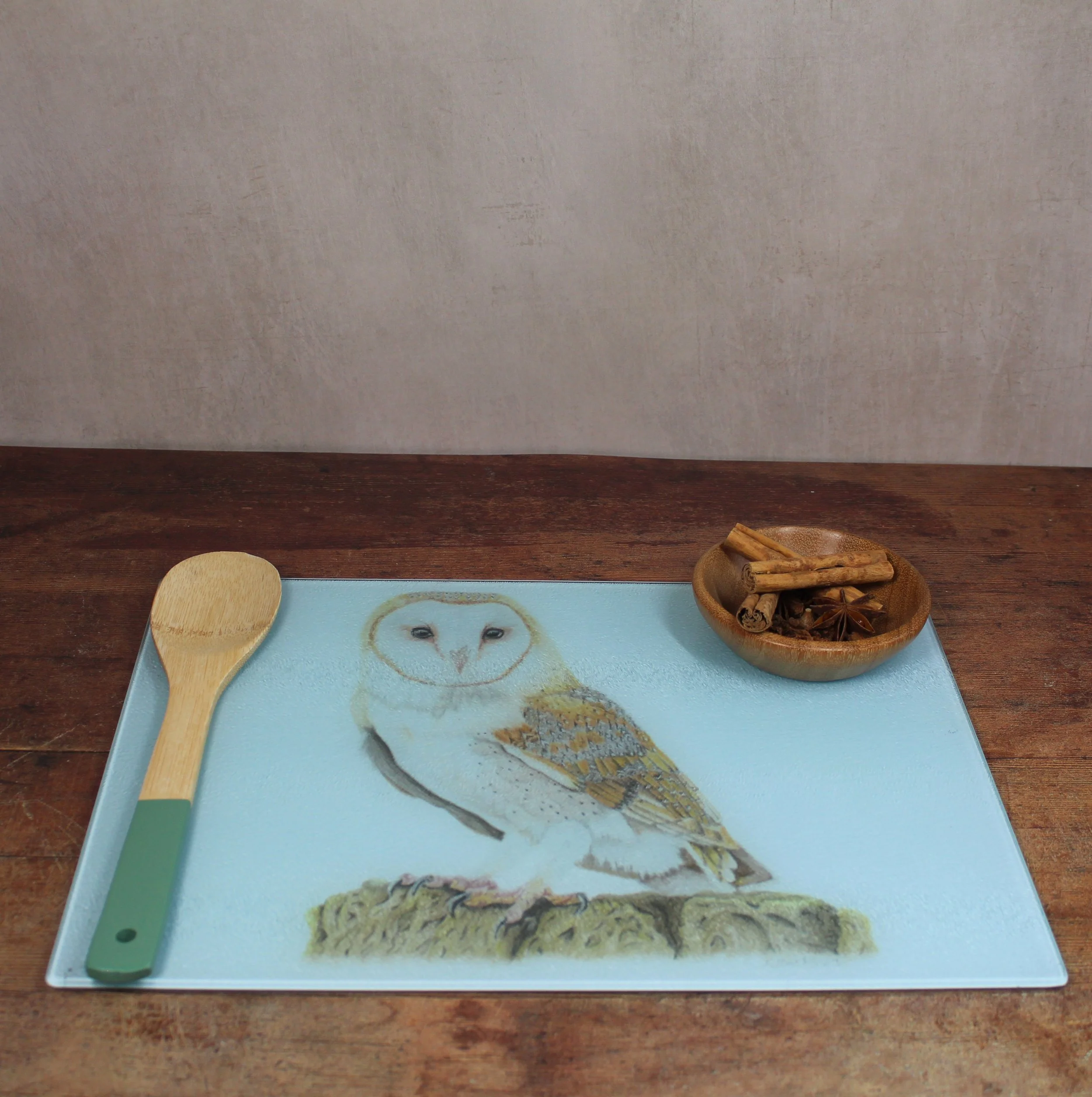 A barn owl drawing on a large glass chopping board / worktop saver.