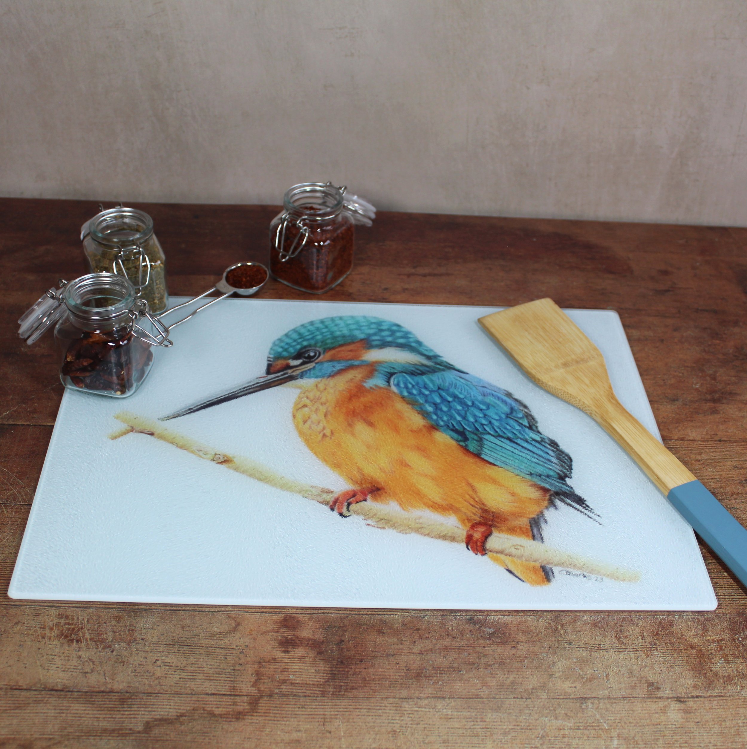 A large glass chopping board with a kingfisher on it.