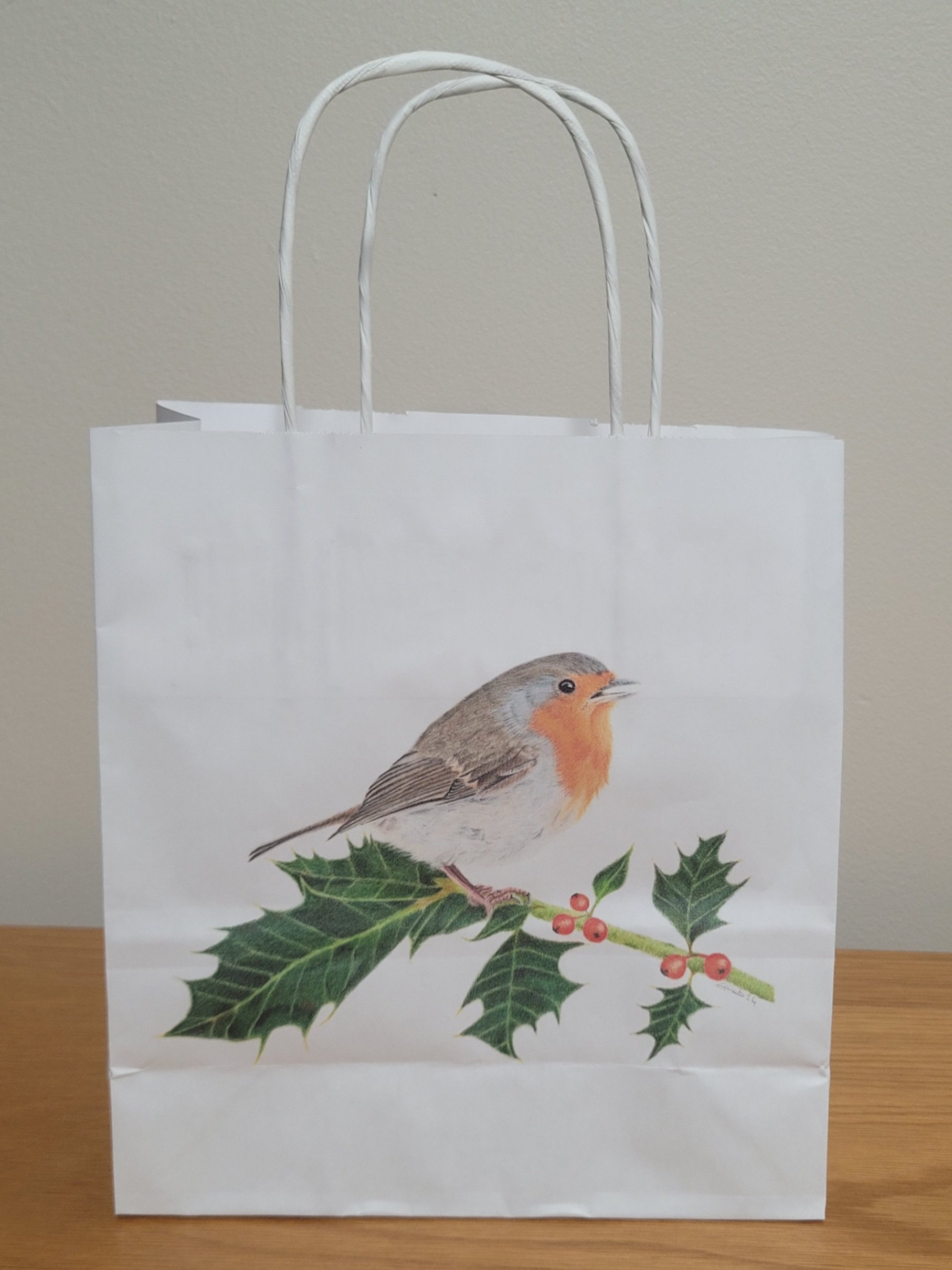 Christmas gift bag featuring a robin on holly.