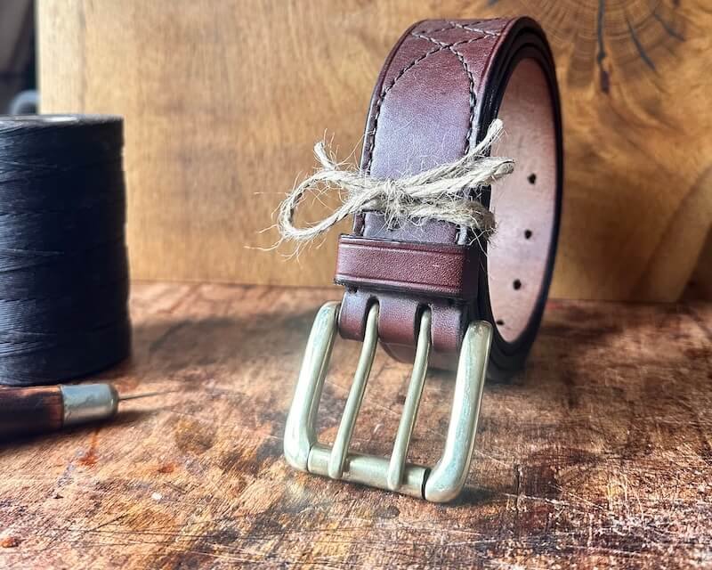Traditional leatherworker making a leather belt by hand in Devon