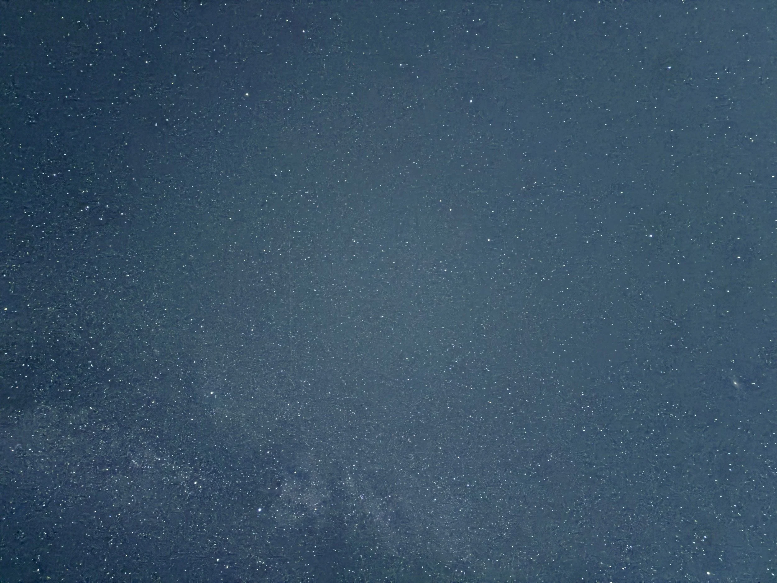 Night sky filled with stars and a faint celestial cloud or nebula.